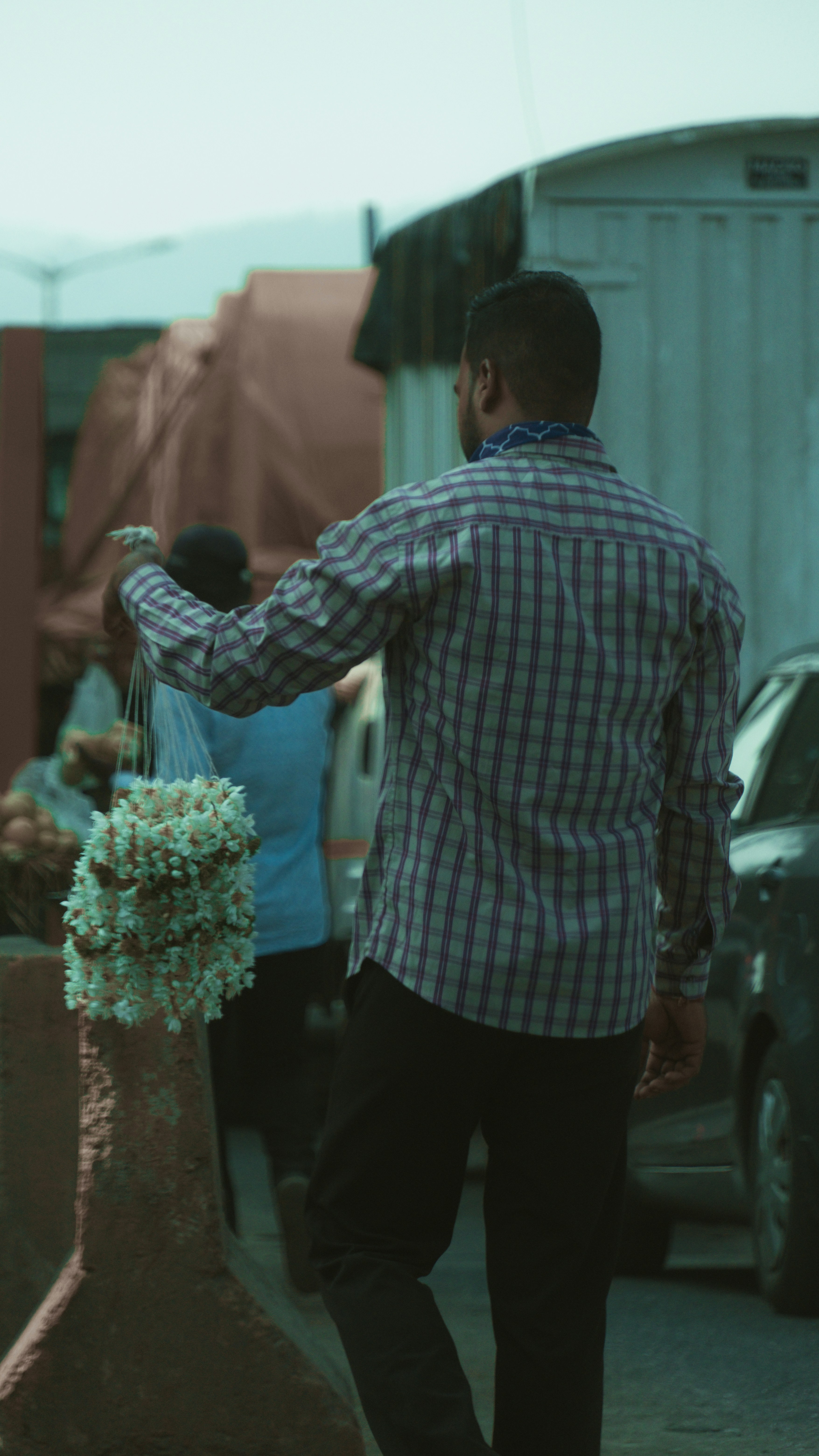 A man walking down a street next to parked cars