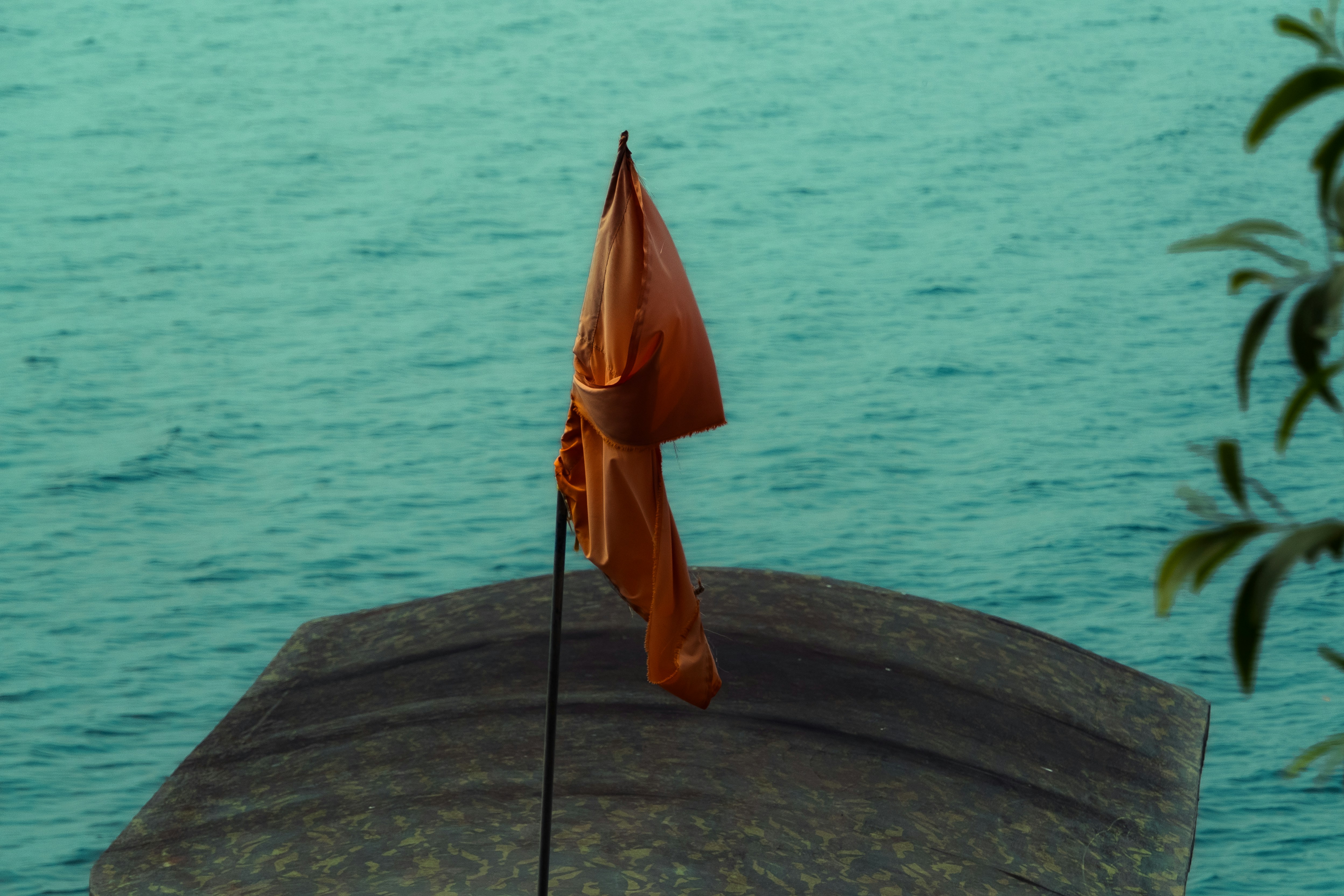 An orange umbrella sitting on top of a stone wall