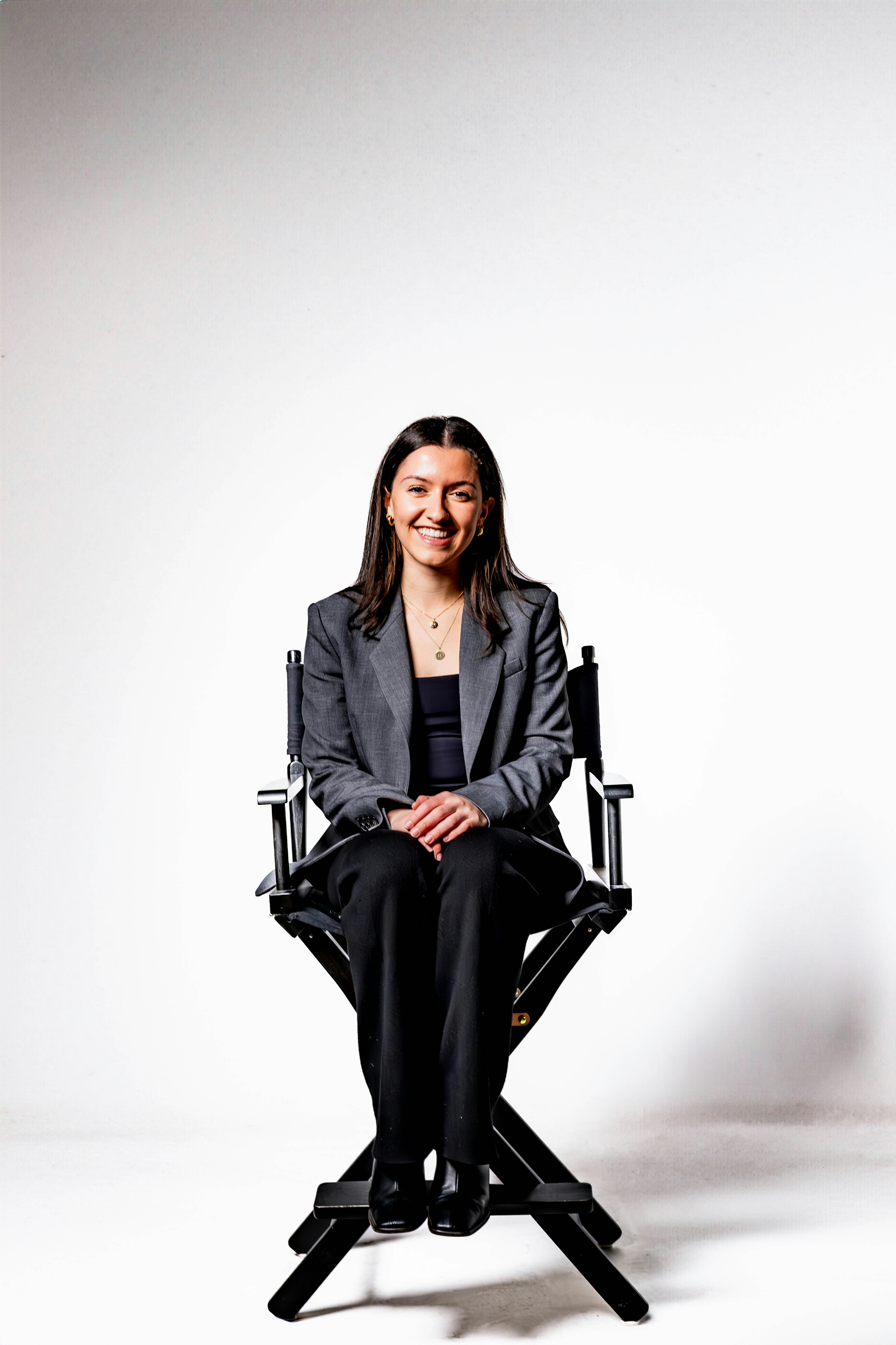 Eine Frau, die mit einem Lächeln im Gesicht auf einem Stuhl sitzt