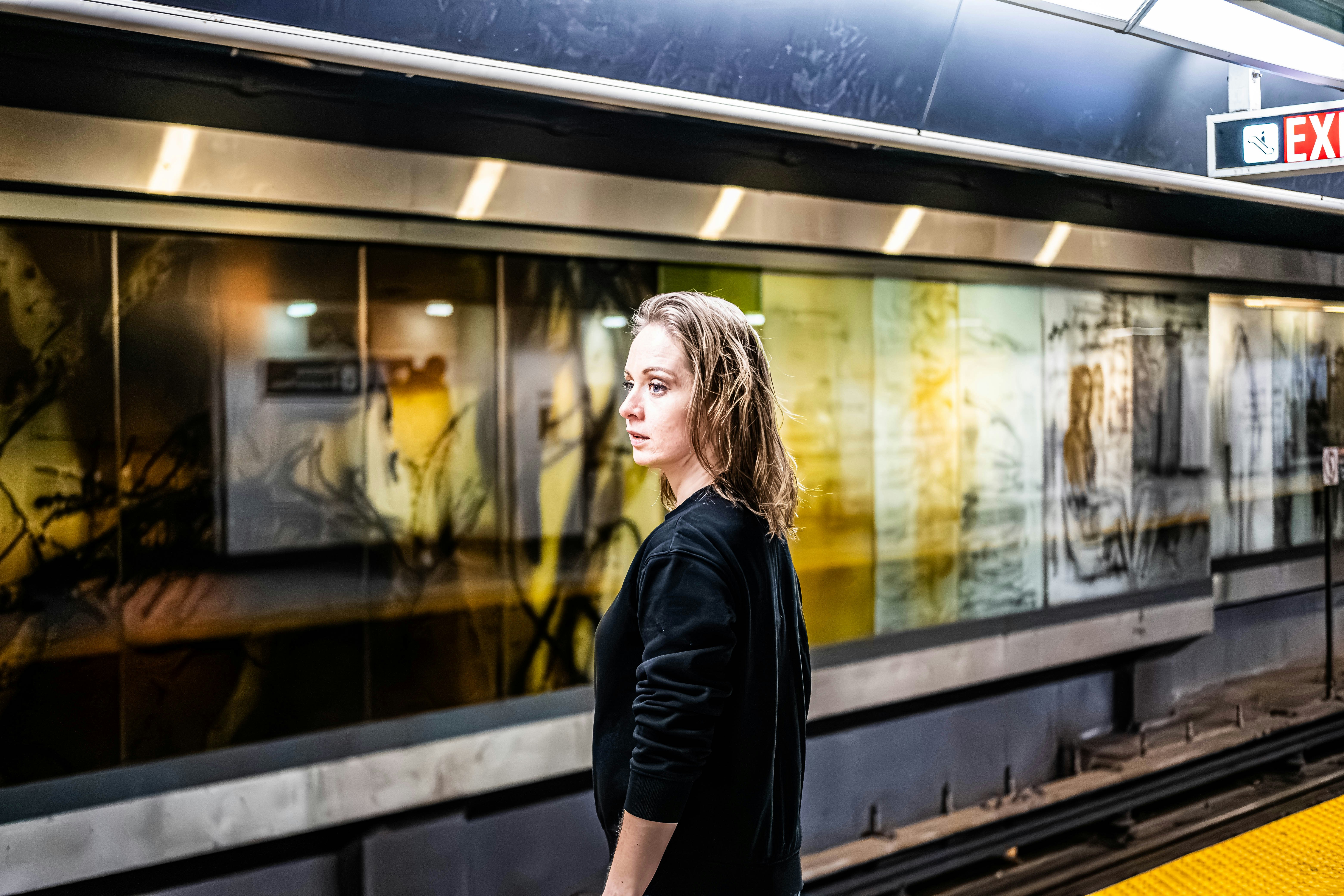 Eine Frau, die an einem Bahnhof auf einen Zug wartet