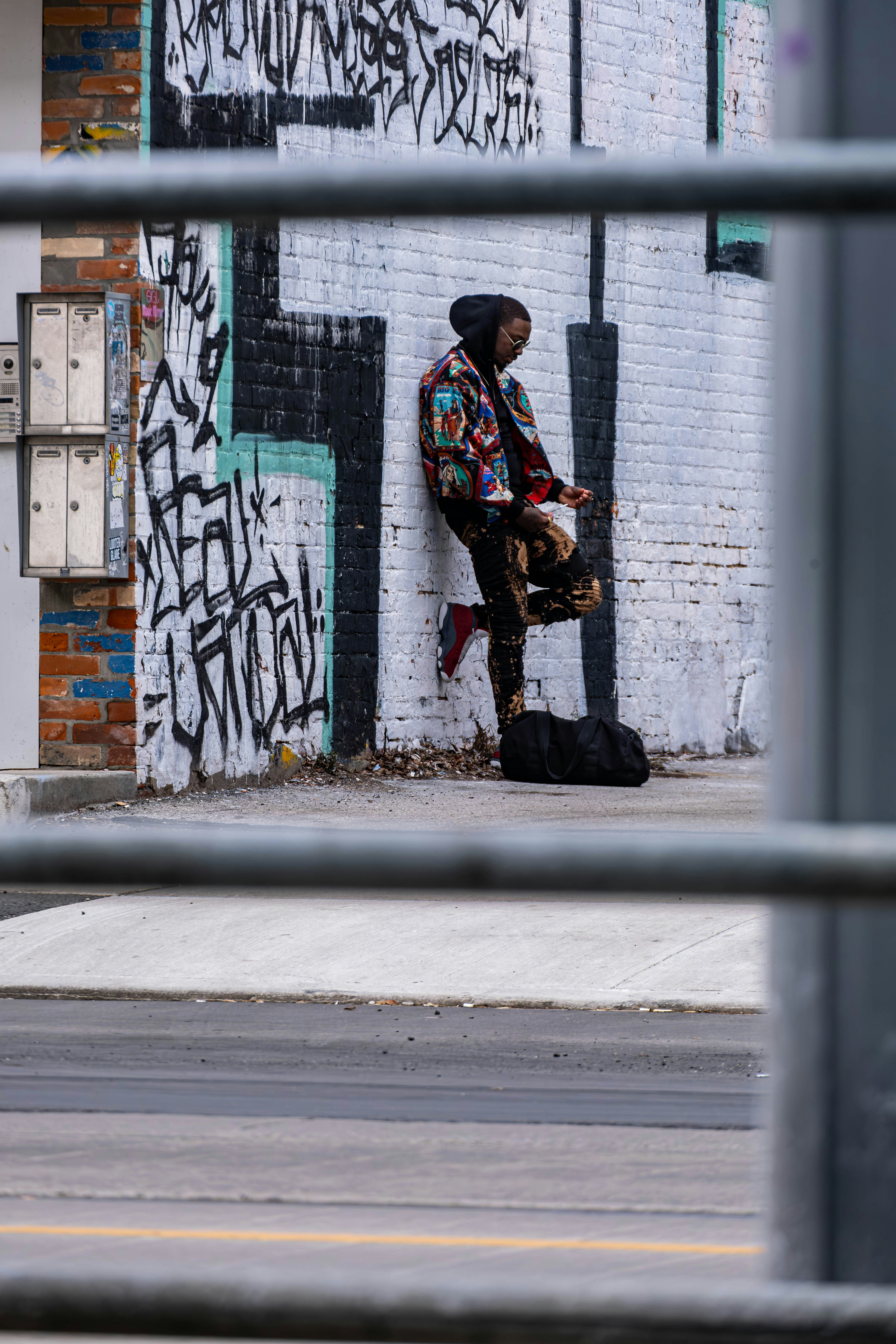 Ein Mann mit einem Skateboard, der an einer Wand lehnt