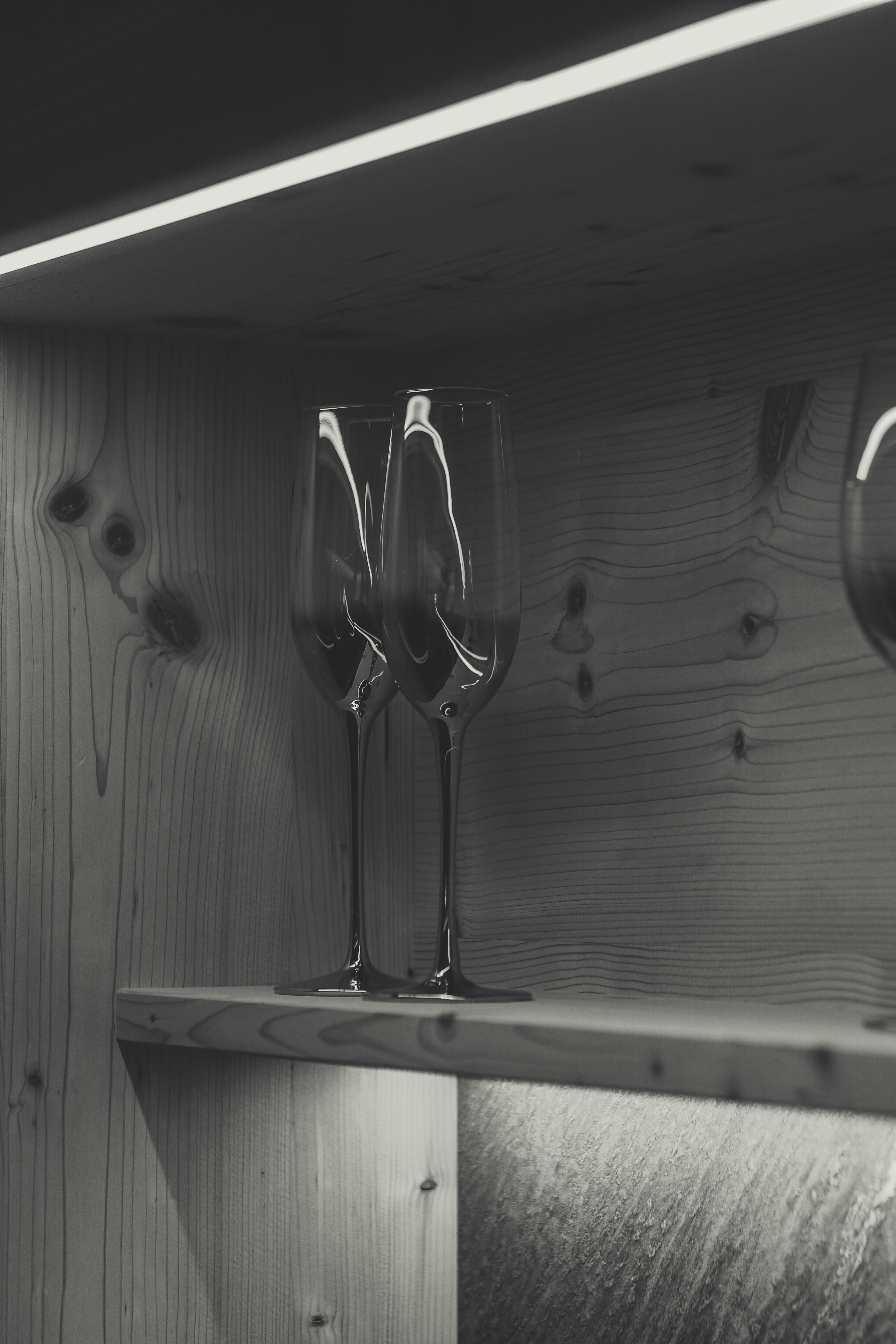 A couple of wine glasses sitting on top of a shelf