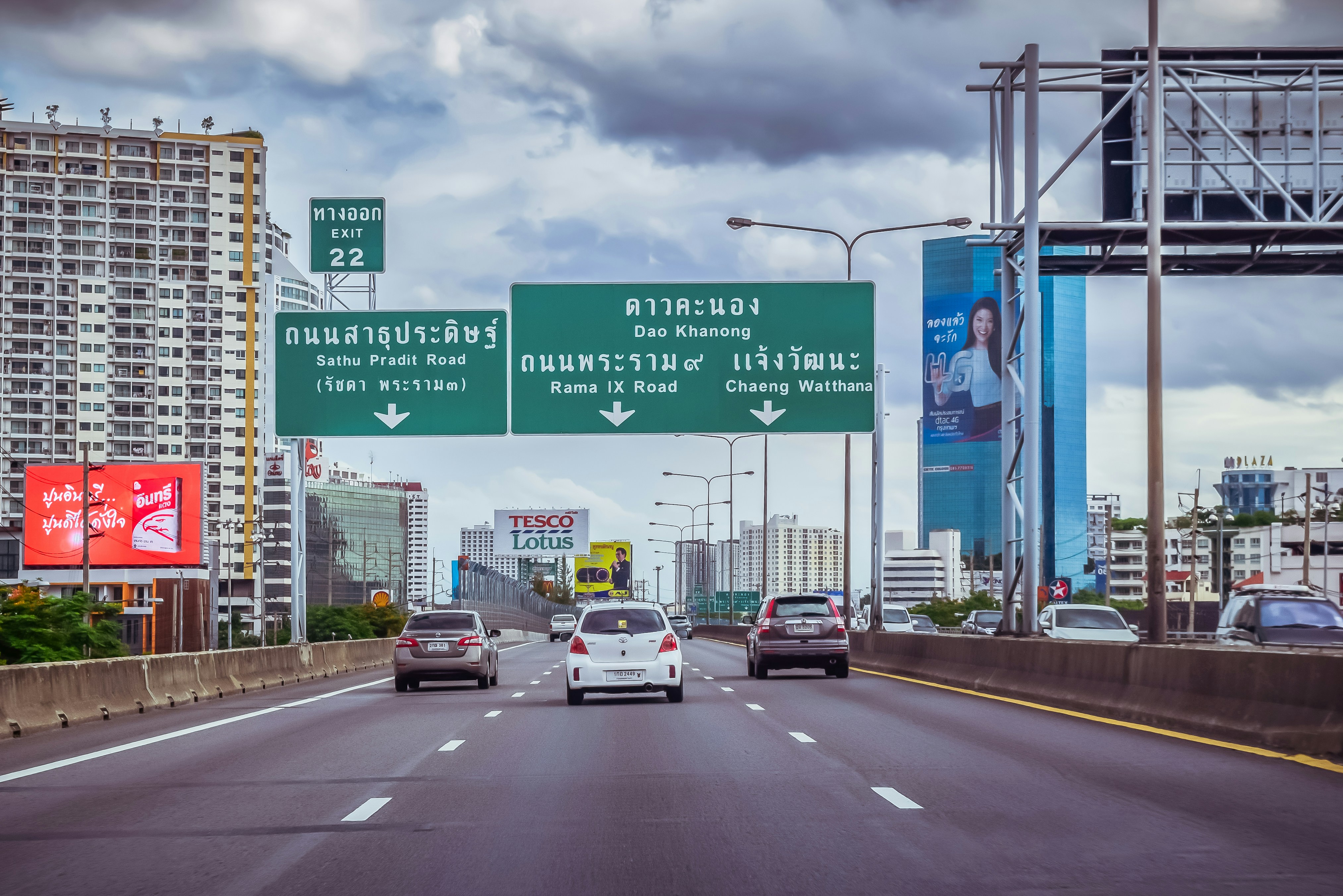 A highway with a bunch of cars driving down it