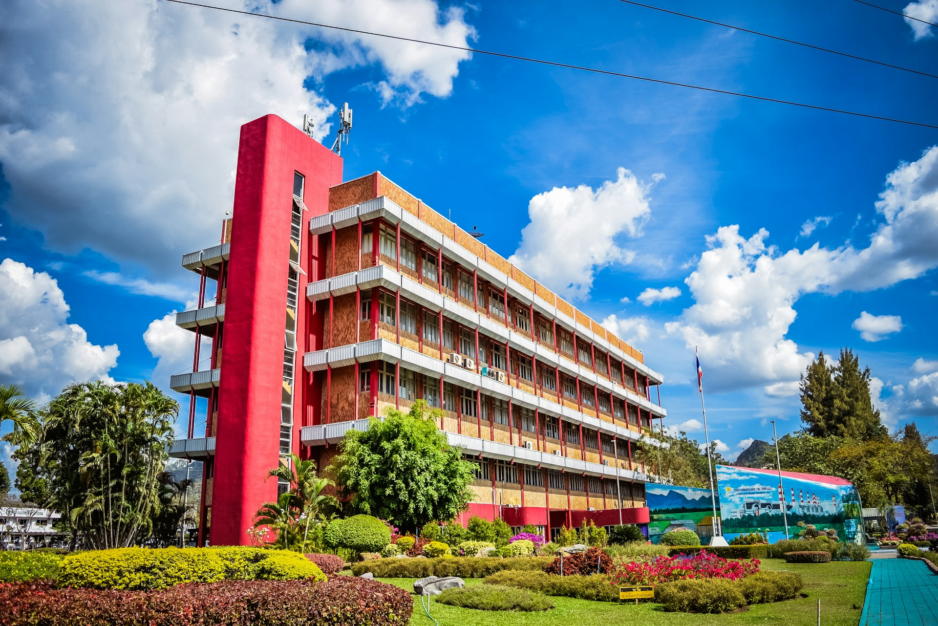 A large red building sitting next to a lush green park