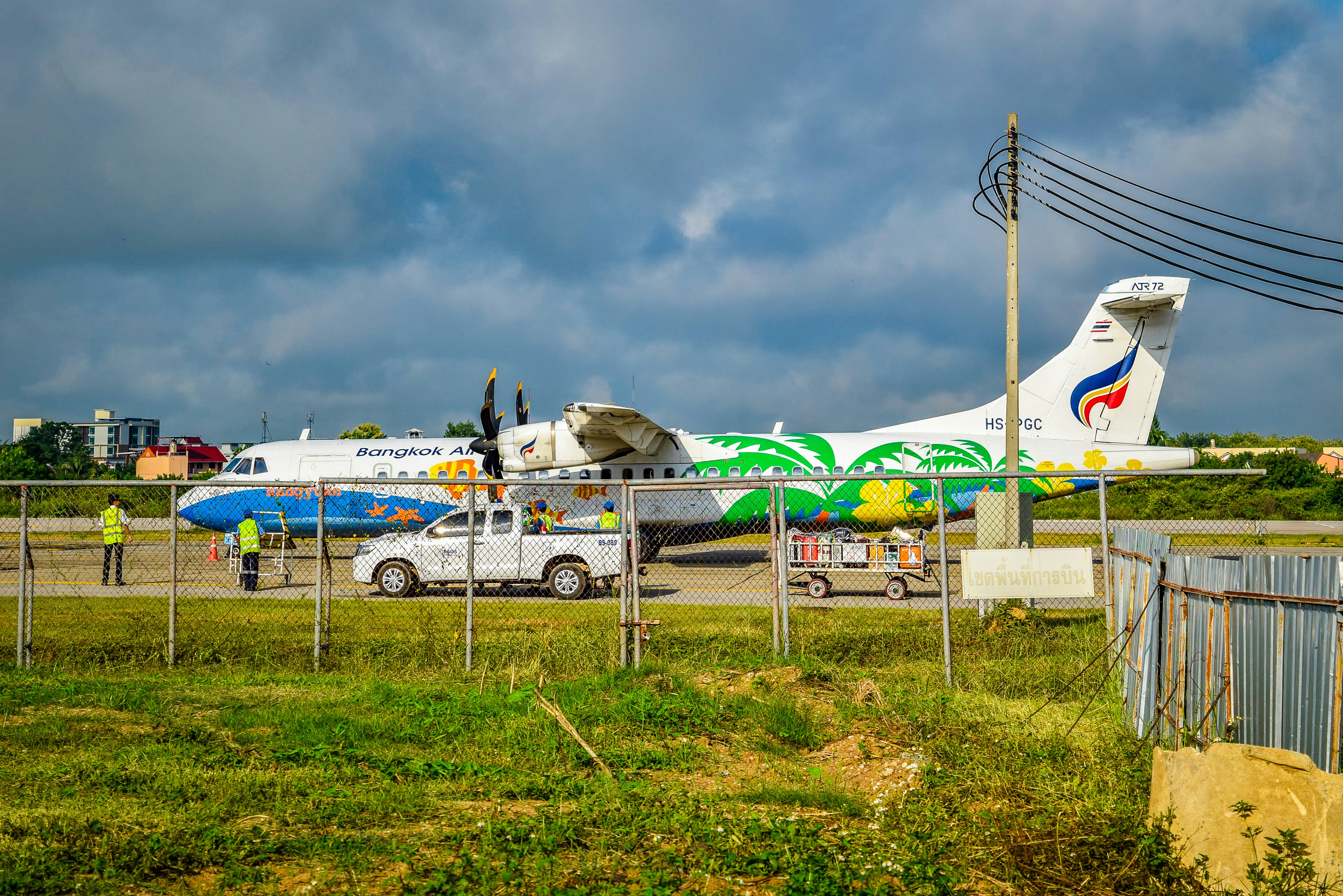A large jetliner sitting on top of an airport tarmac, ATR 72-500 [HS-PGC] Parked on ramp at Lampang Airport.