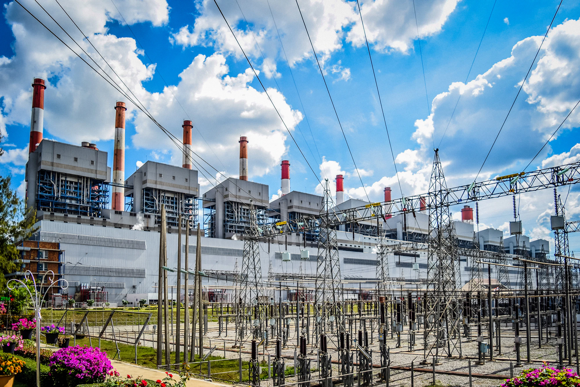 Power plant and electrical substation against a blue sky