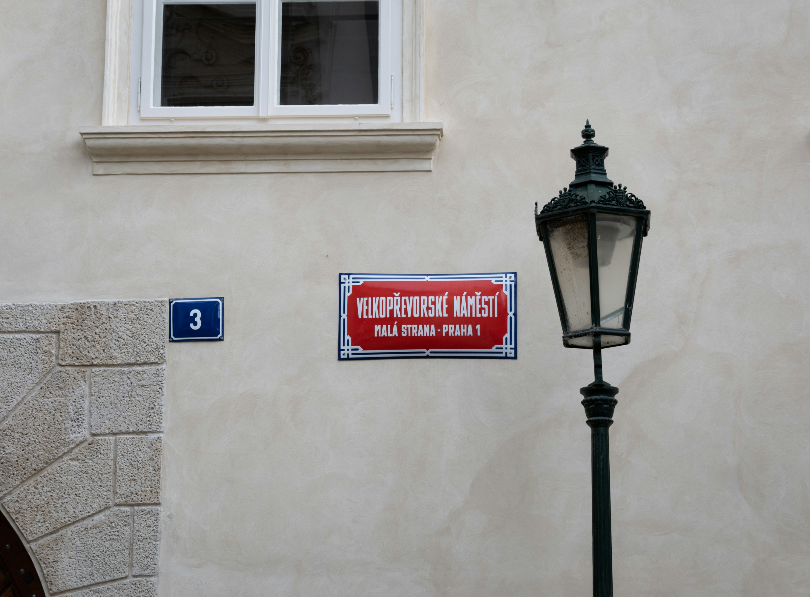 A street light sitting next to a white building