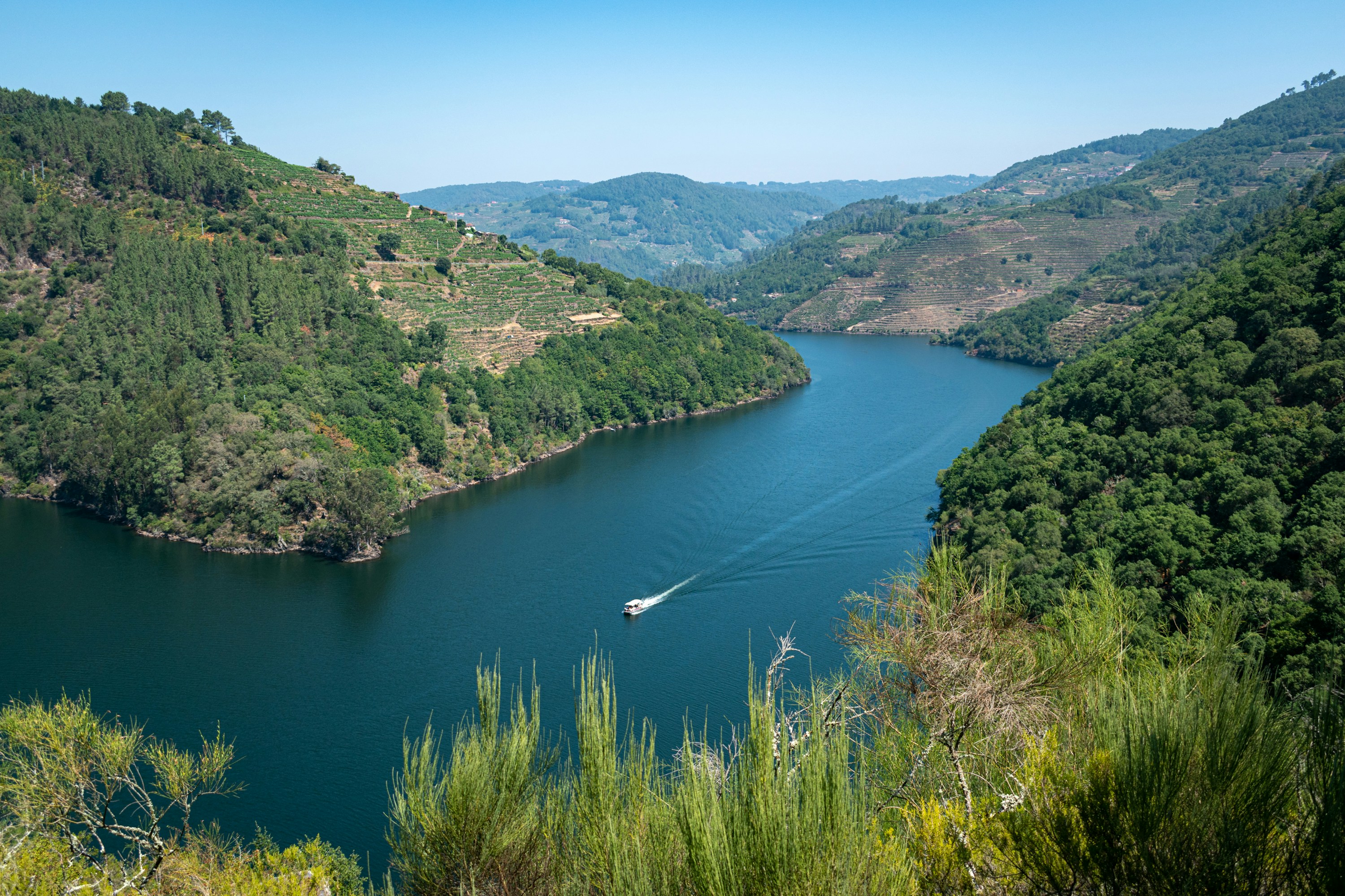 A large body of water surrounded by lush green hills