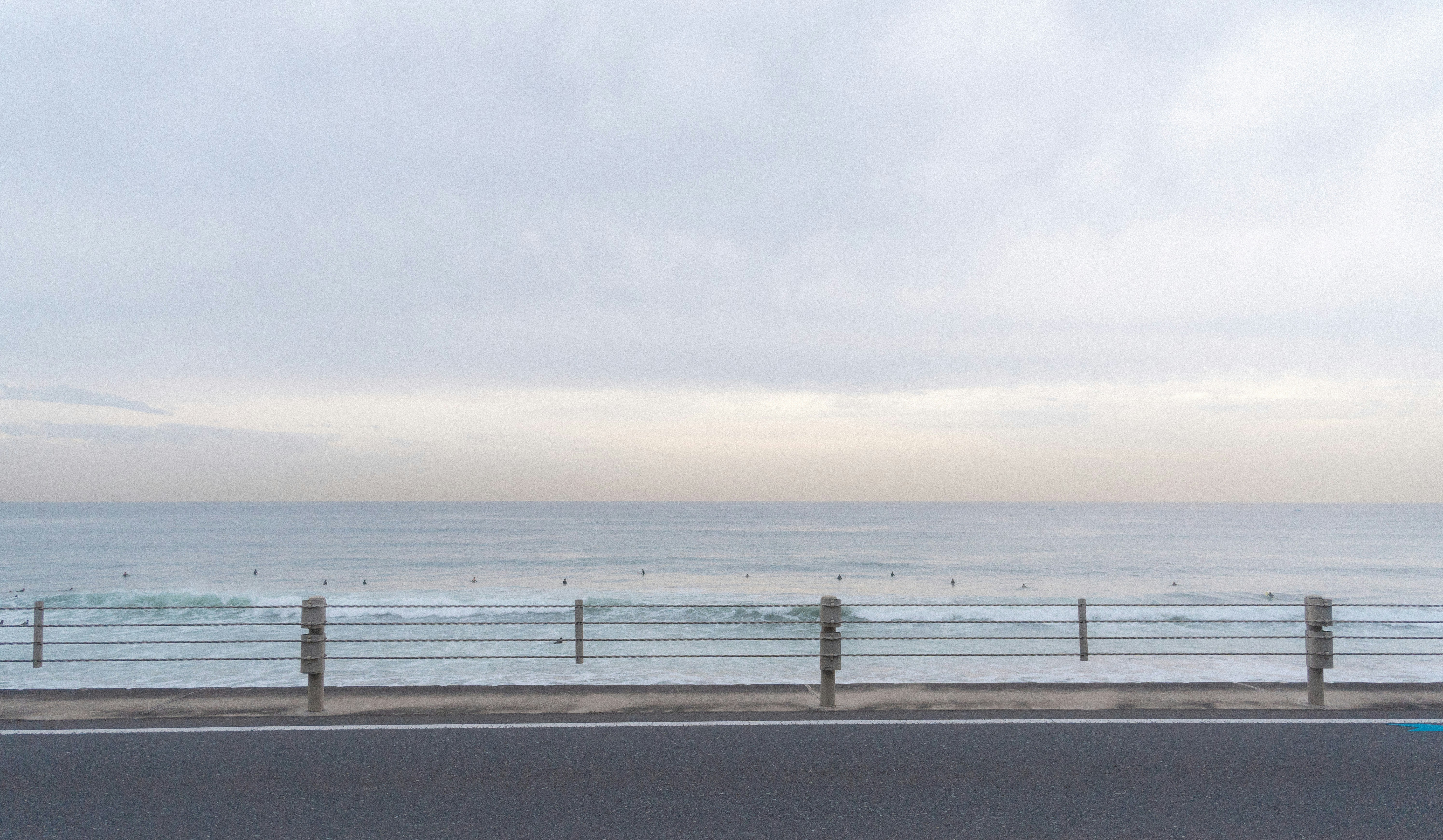 A car driving down a road next to the ocean