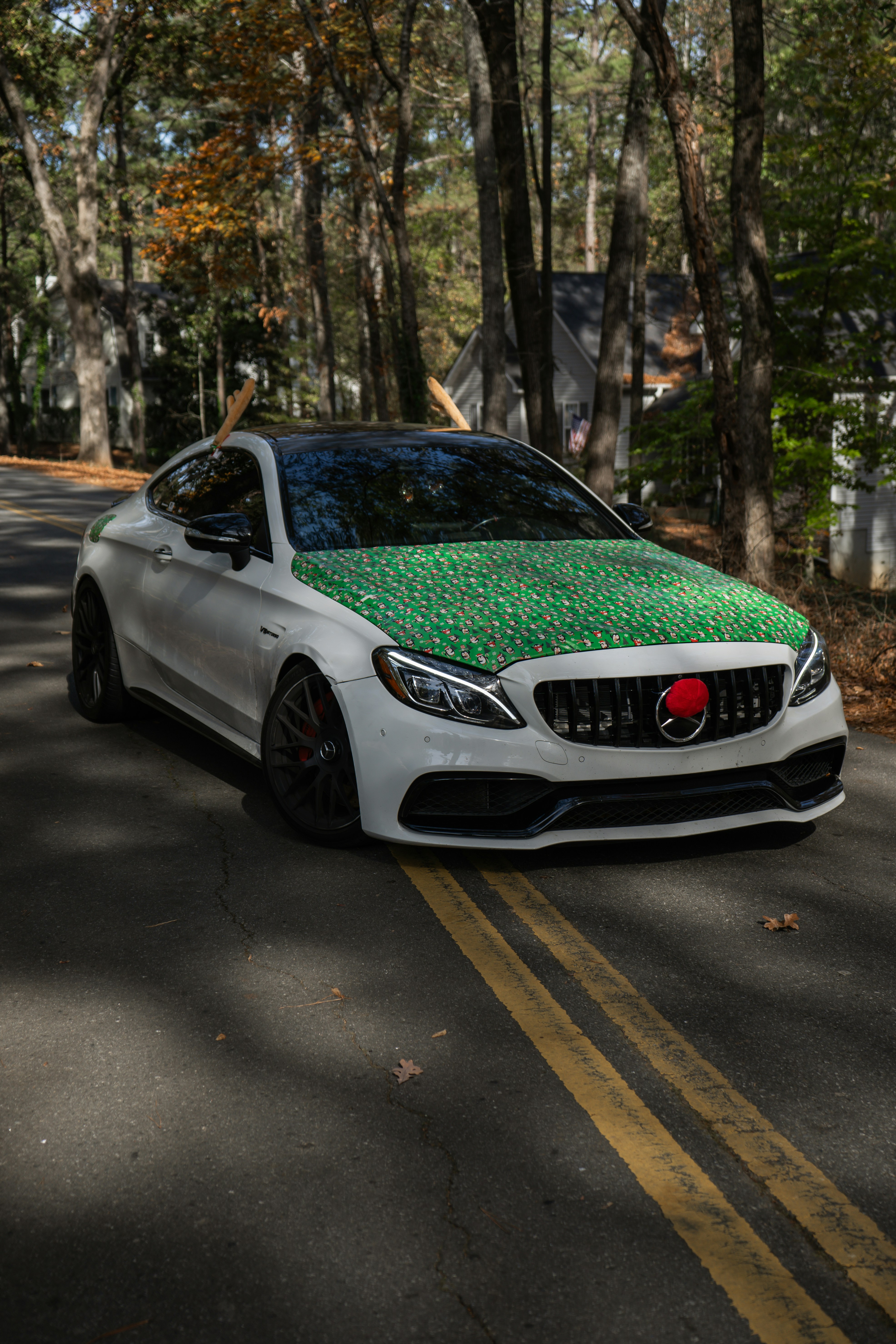 A white car with a green wrap around it