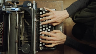 A person typing on an old fashioned typewriter