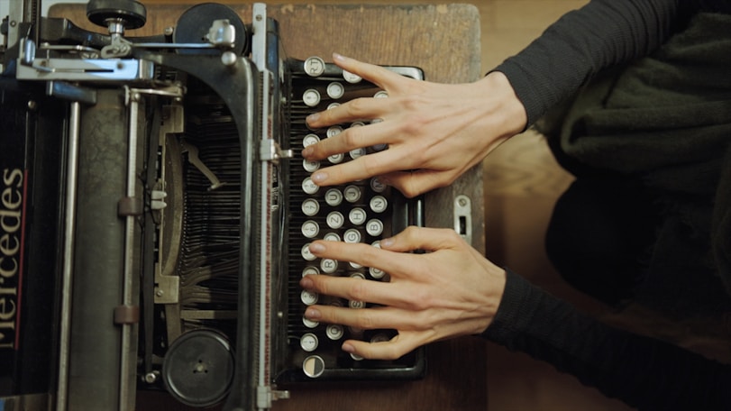 A person typing on an old fashioned typewriter