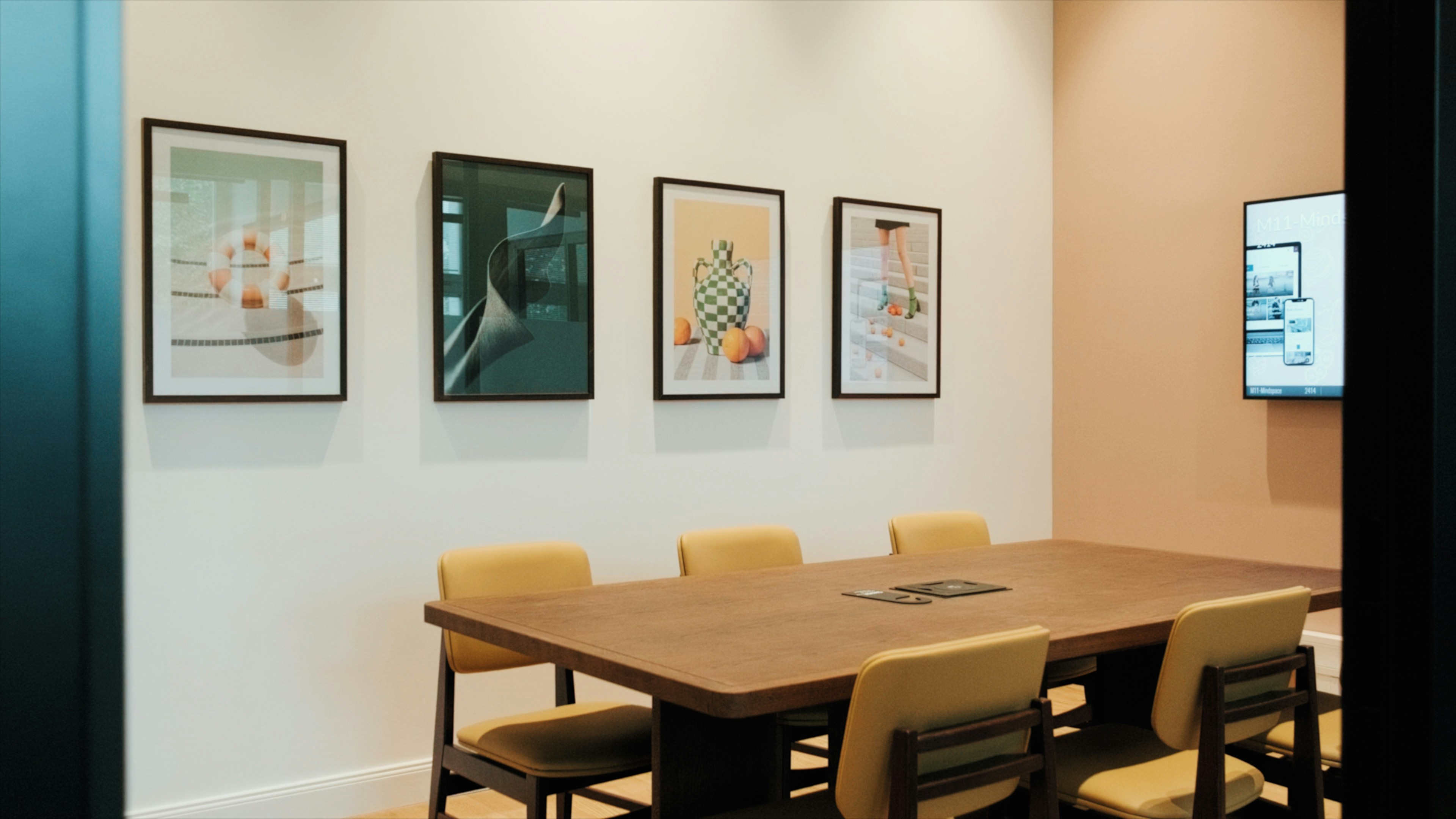 A room with a table and chairs and pictures on the wall