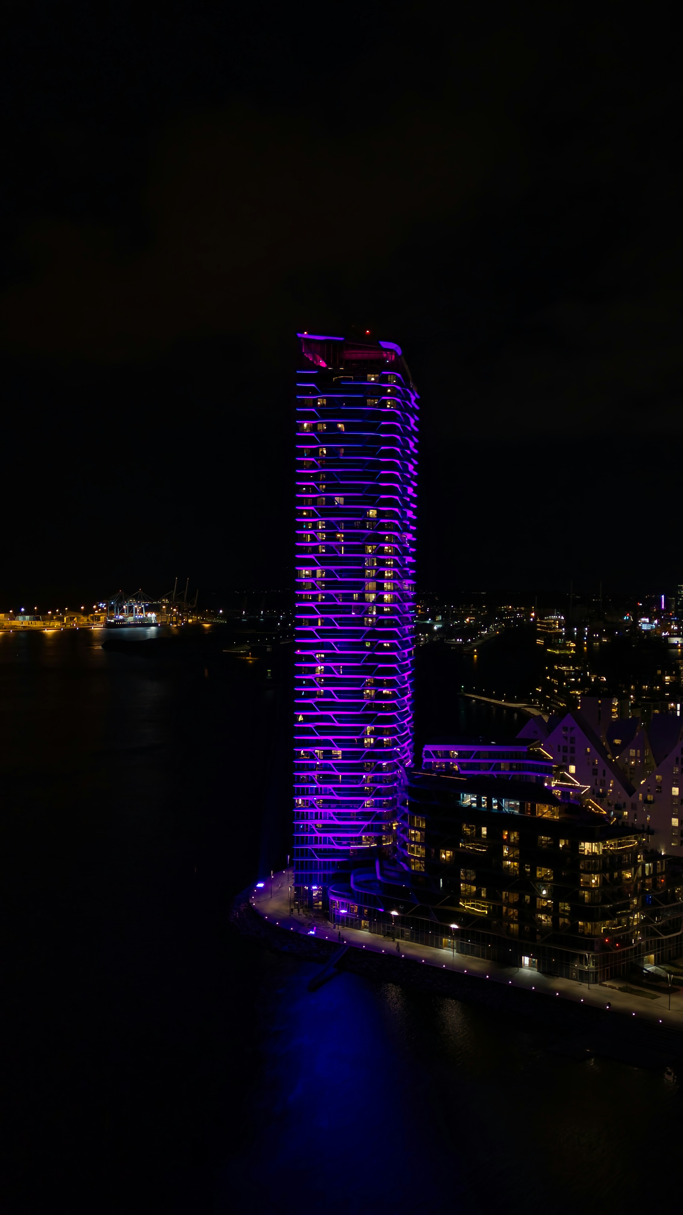 A night view of a city with a purple building