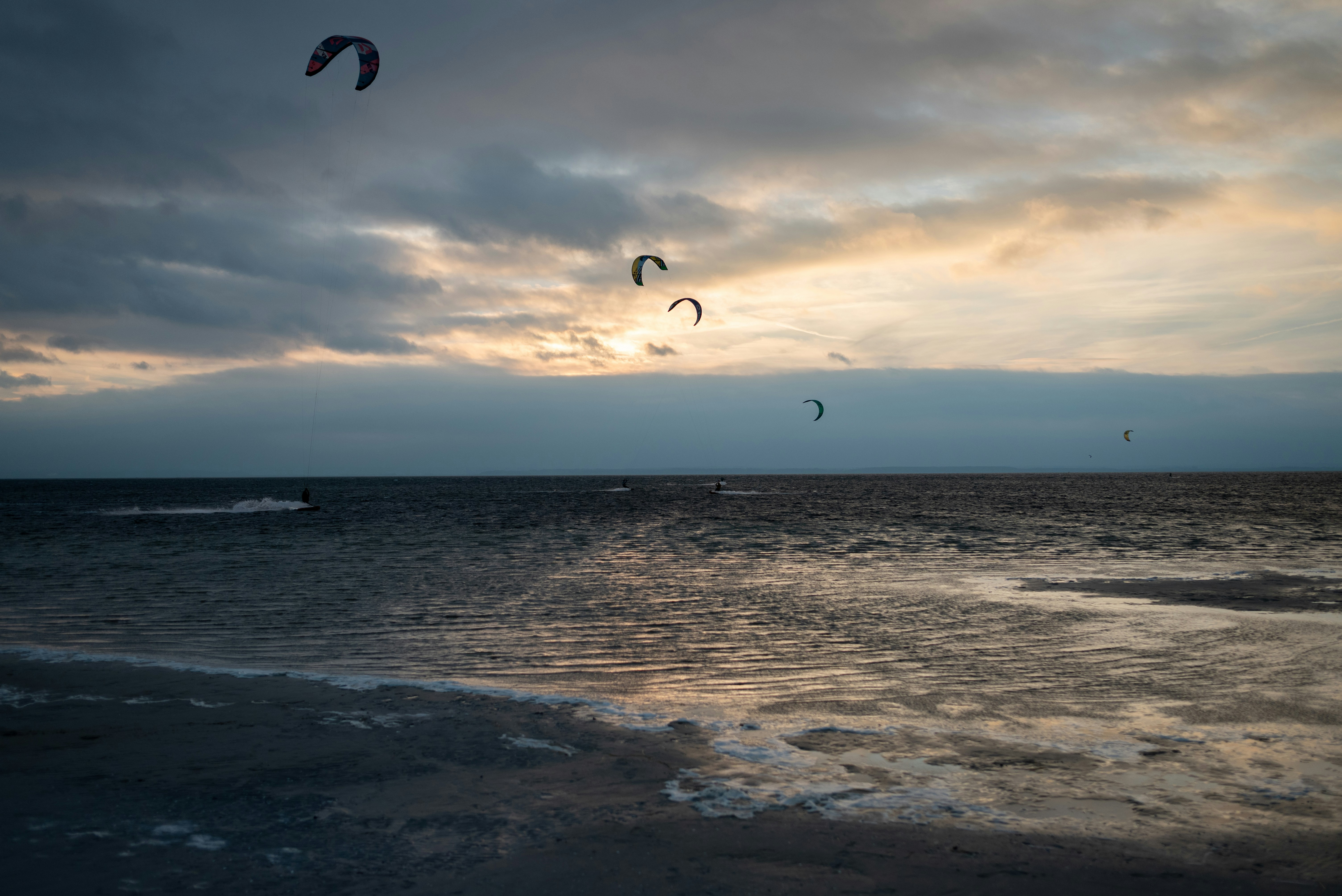 A couple of kites flying over a body of water