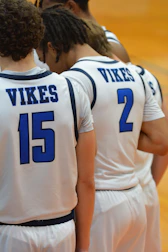 A group of young men standing next to each other on a basketball court