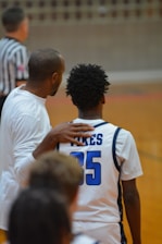 A couple of men standing next to each other on a basketball court