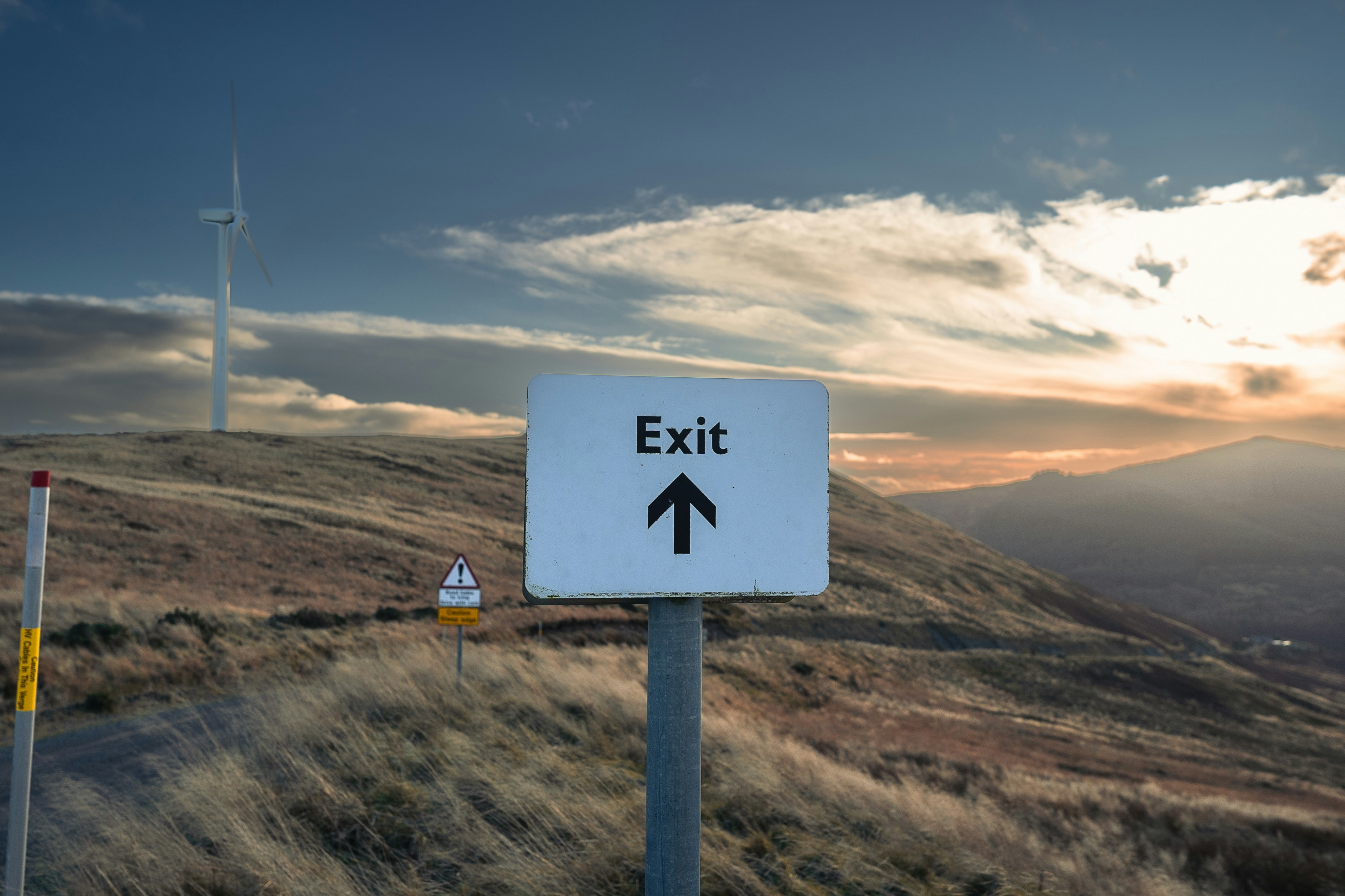 A sign pointing to an exit on a hill