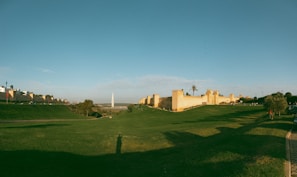 A grassy field with a building in the background
