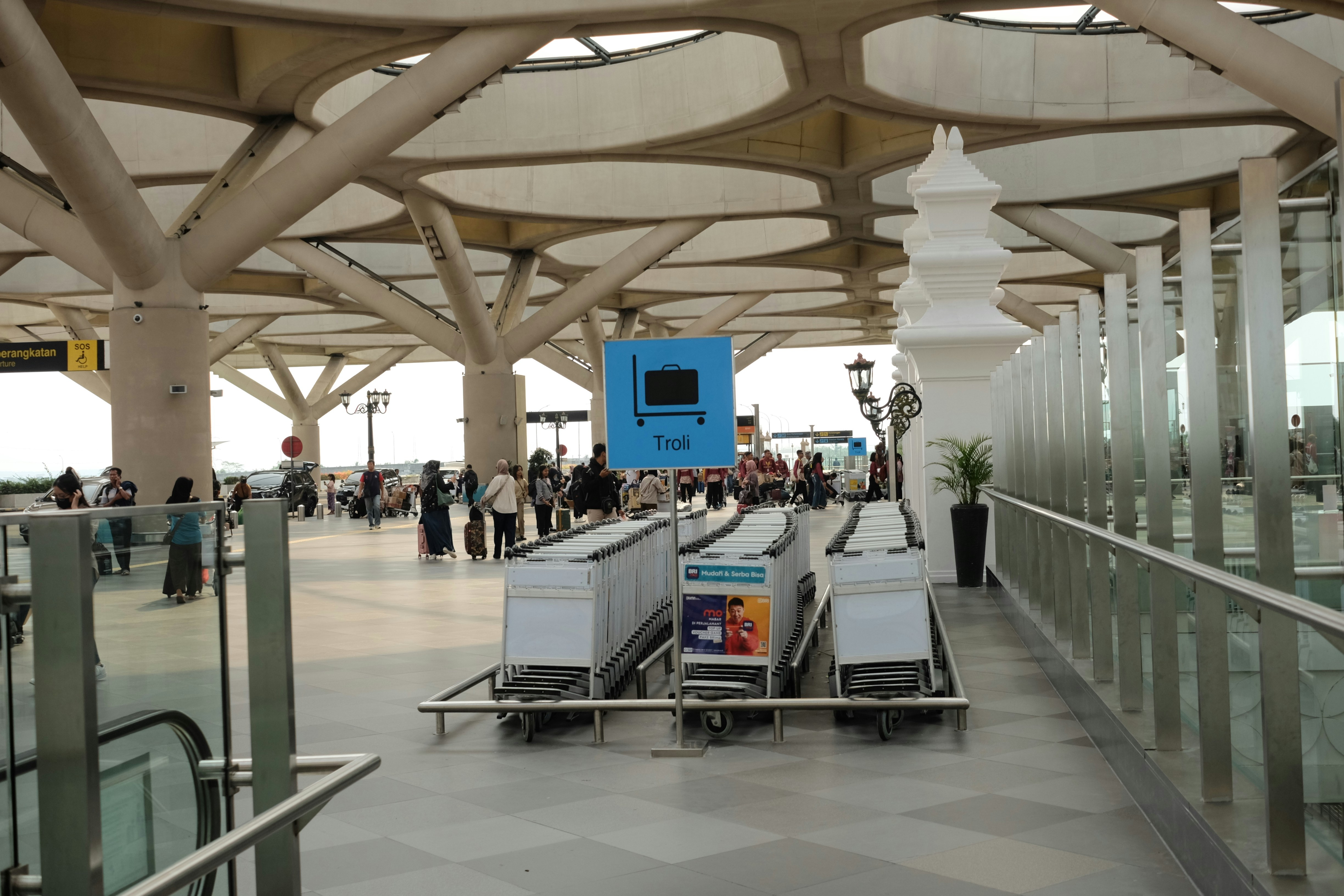 A group of luggage carts sitting inside of an airport, Sign system in YIA Indonesia.Troli Area