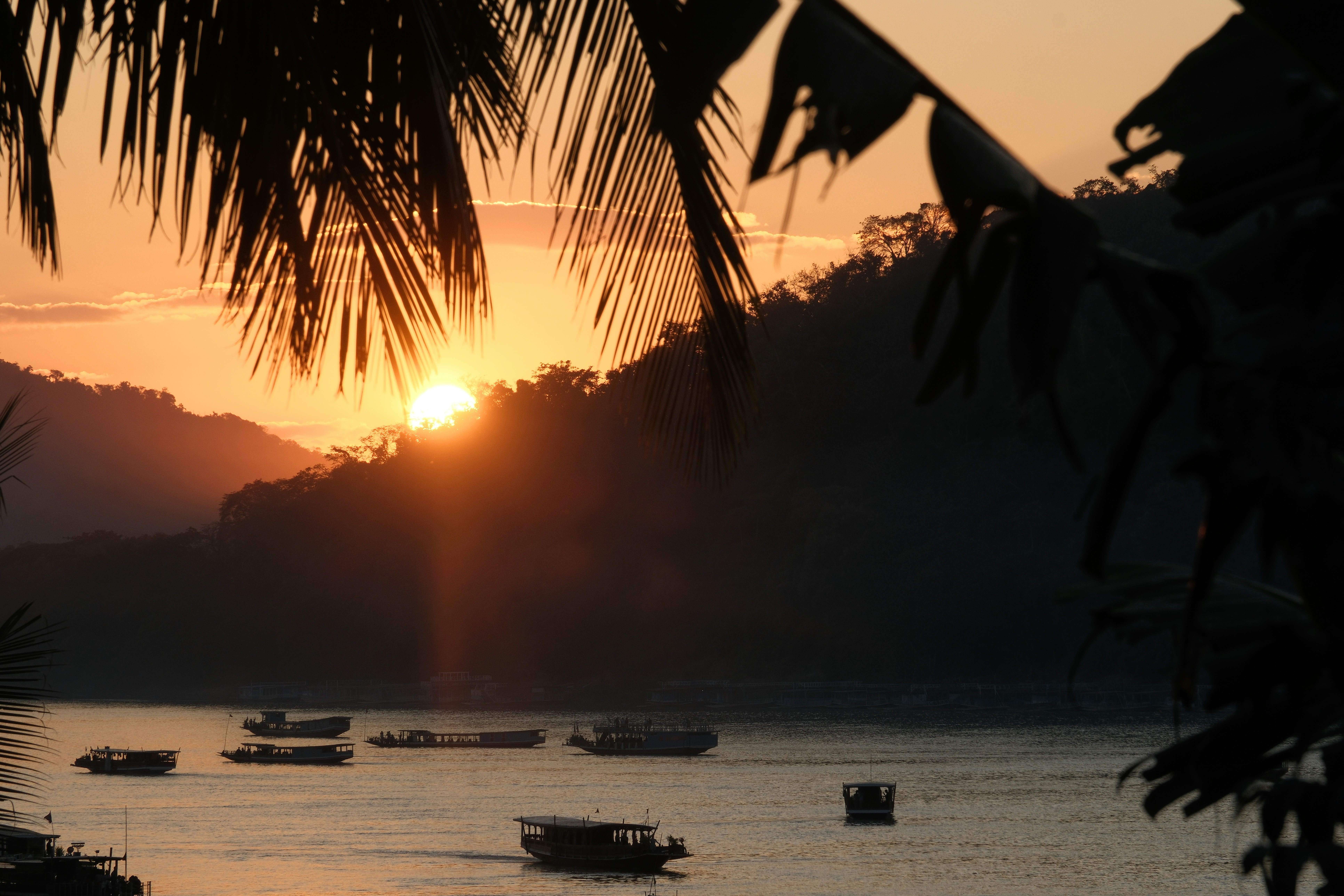 Mekong River, Southeast Asia - Boats on the Mekong river in Luang Prabang, Laos, offer a view on a beautiful sunset
