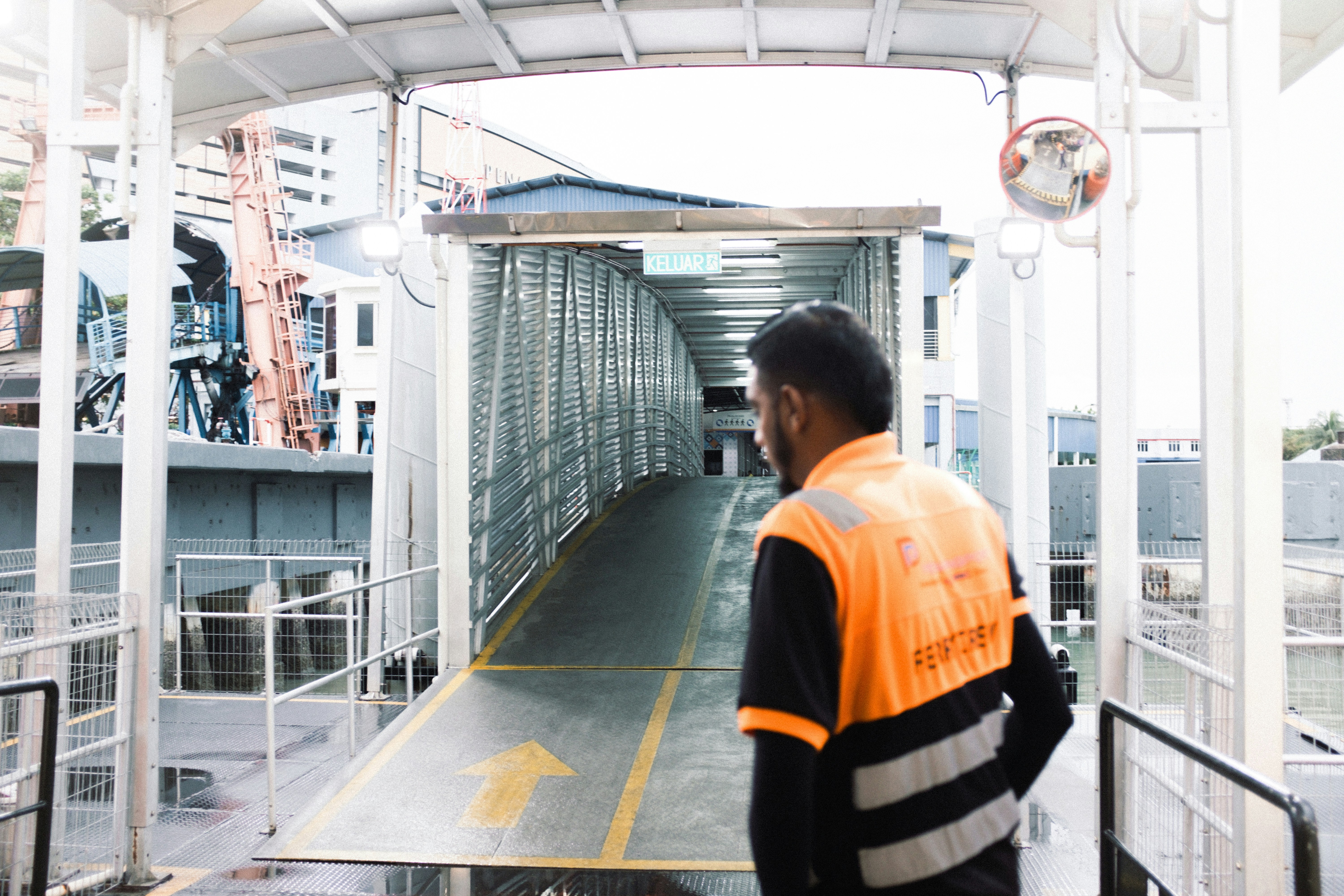 Un uomo in un giubbotto arancione in piedi su una rampa