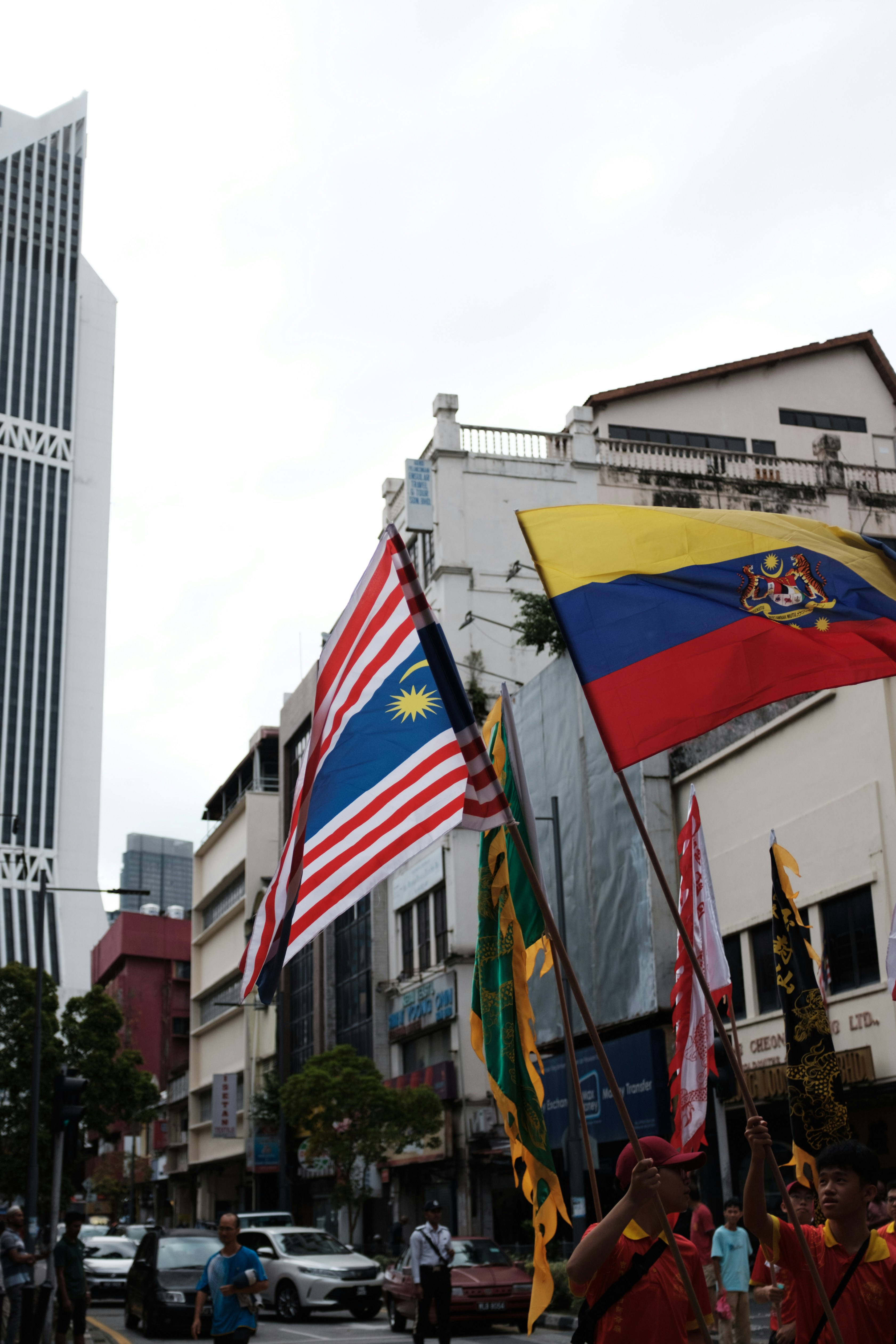 Un gruppo di persone che camminano lungo una strada con bandiere