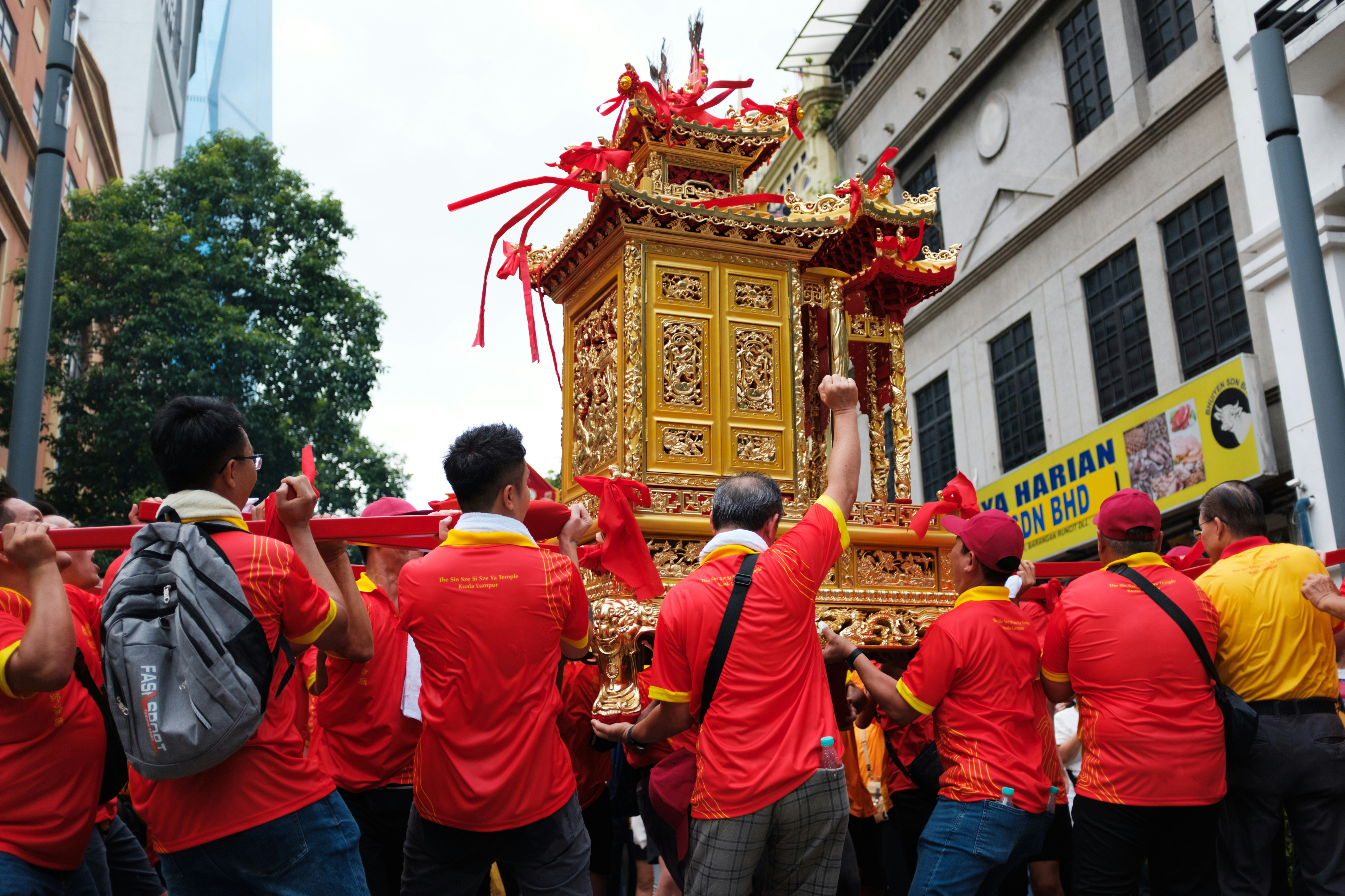 Un gruppo di persone in maglietta rossa in piedi davanti a un carro