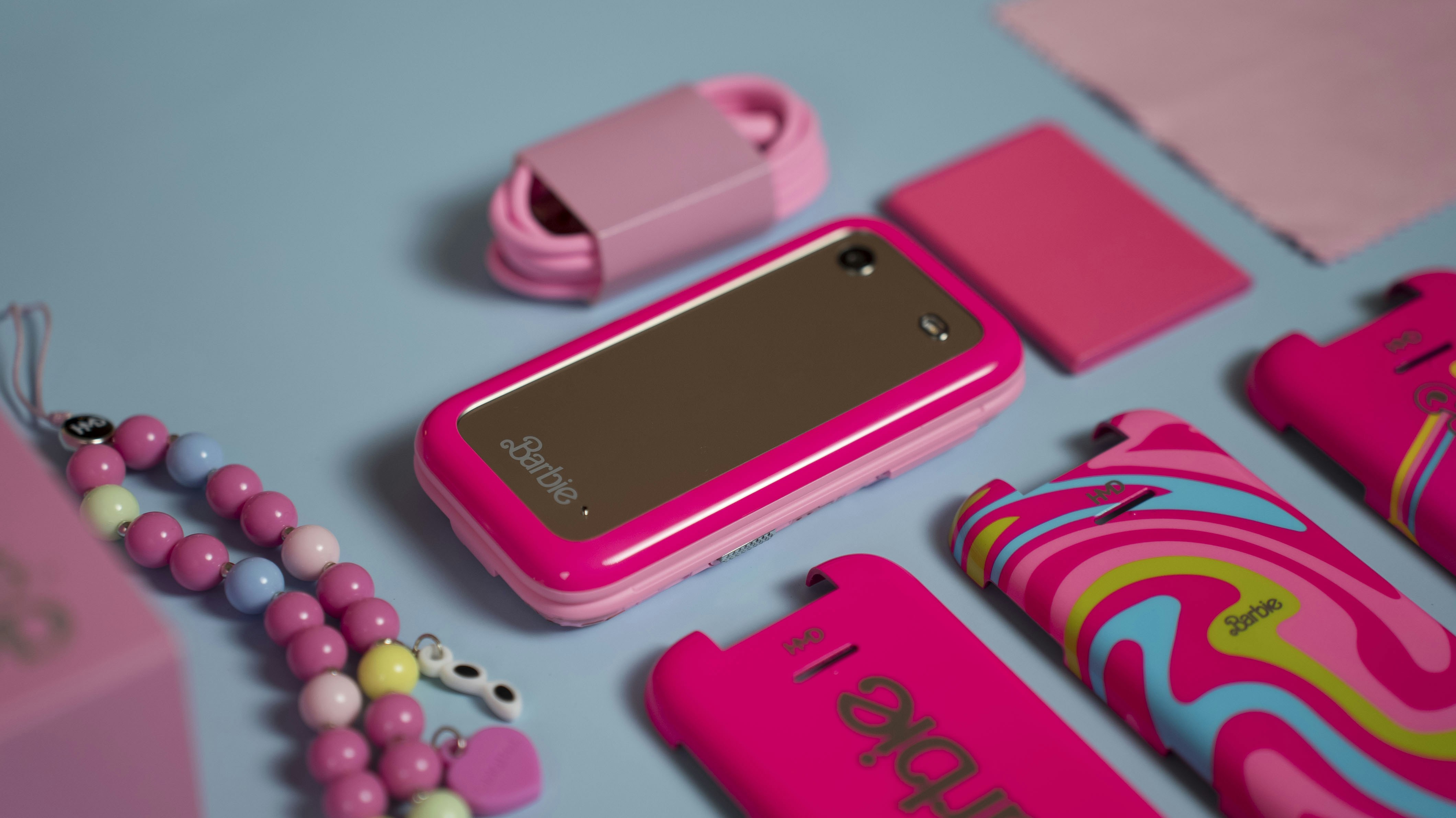 A pink cell phone sitting on top of a blue table