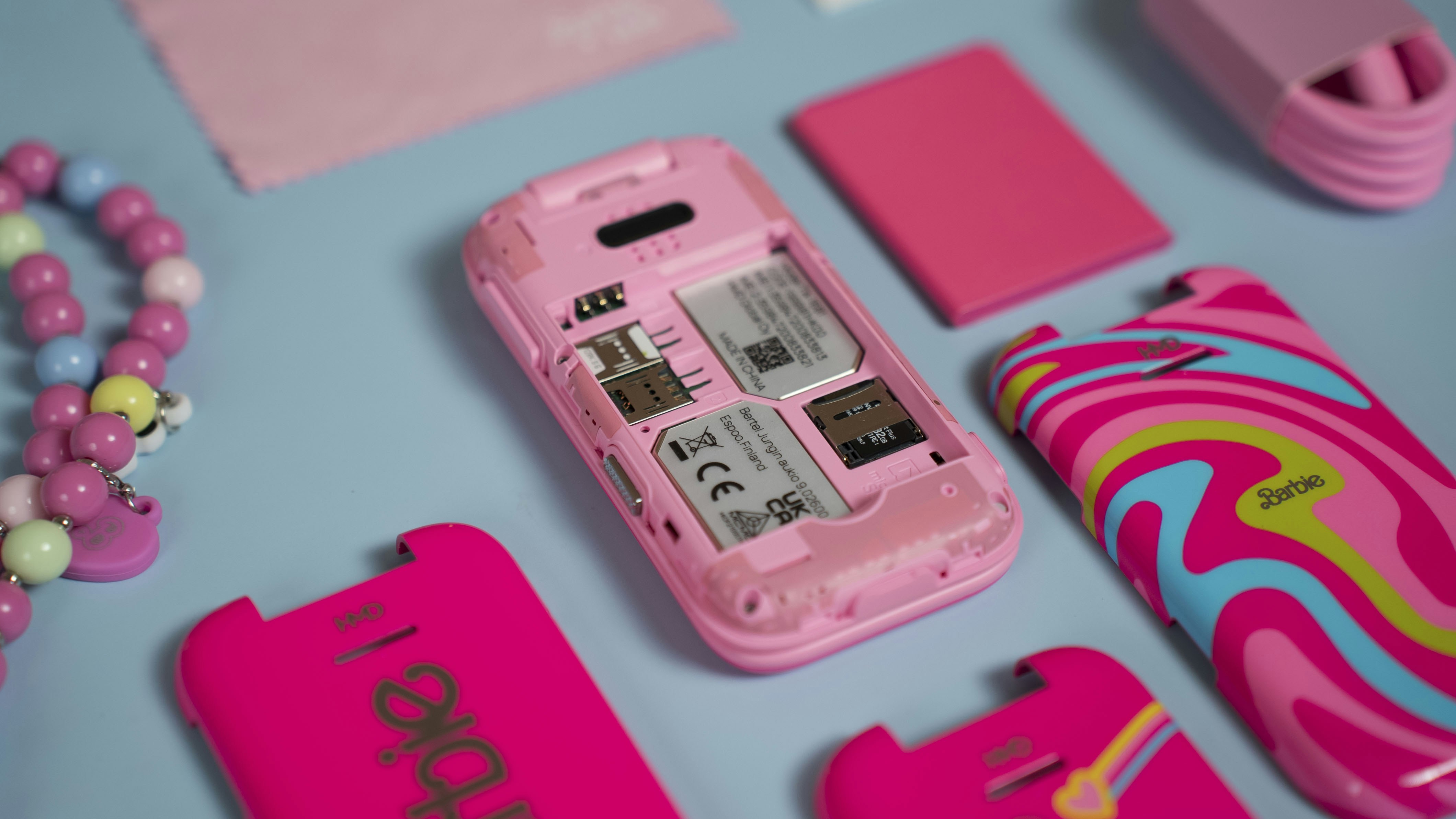 A pink cell phone sitting on top of a blue table