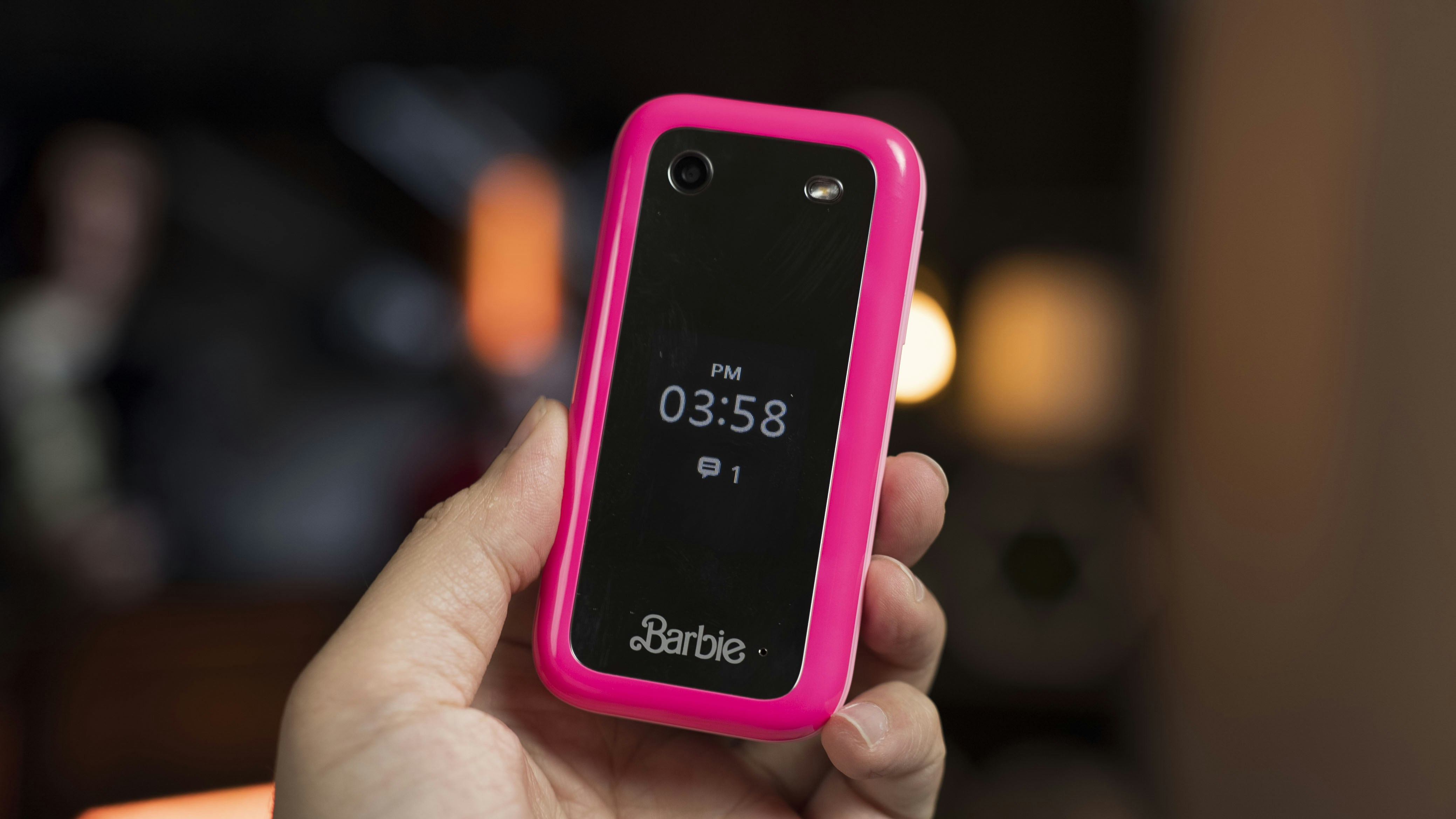 A person holding a pink cell phone in their hand