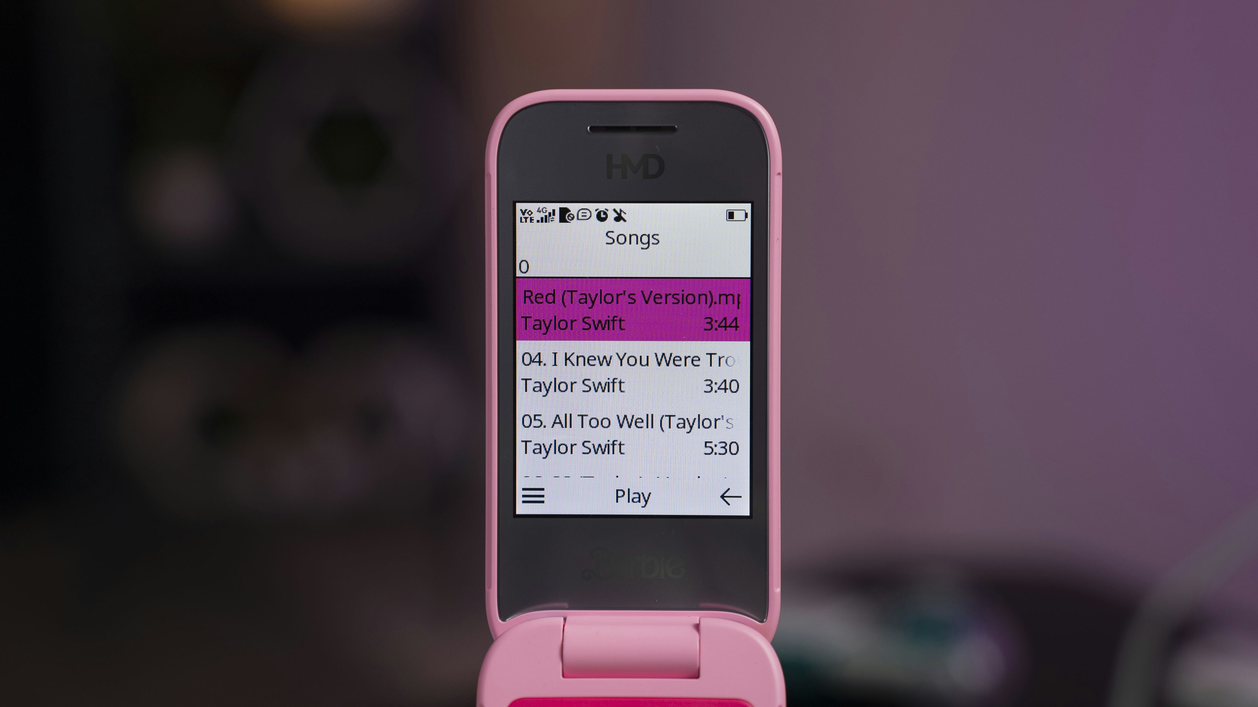 A pink cell phone sitting on top of a table