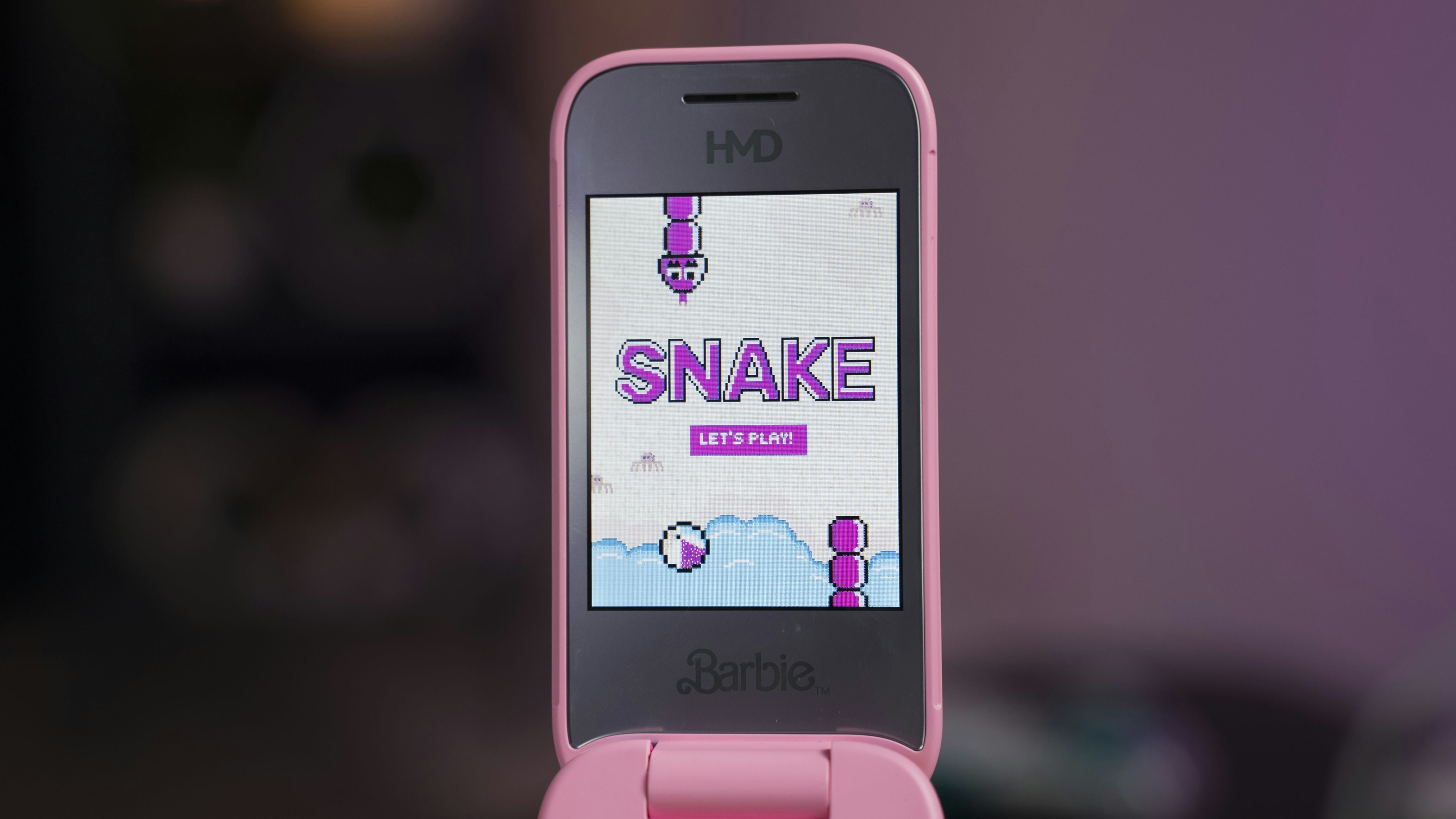 A pink smart phone with a snake on the screen
