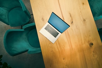 A laptop computer sitting on top of a wooden table