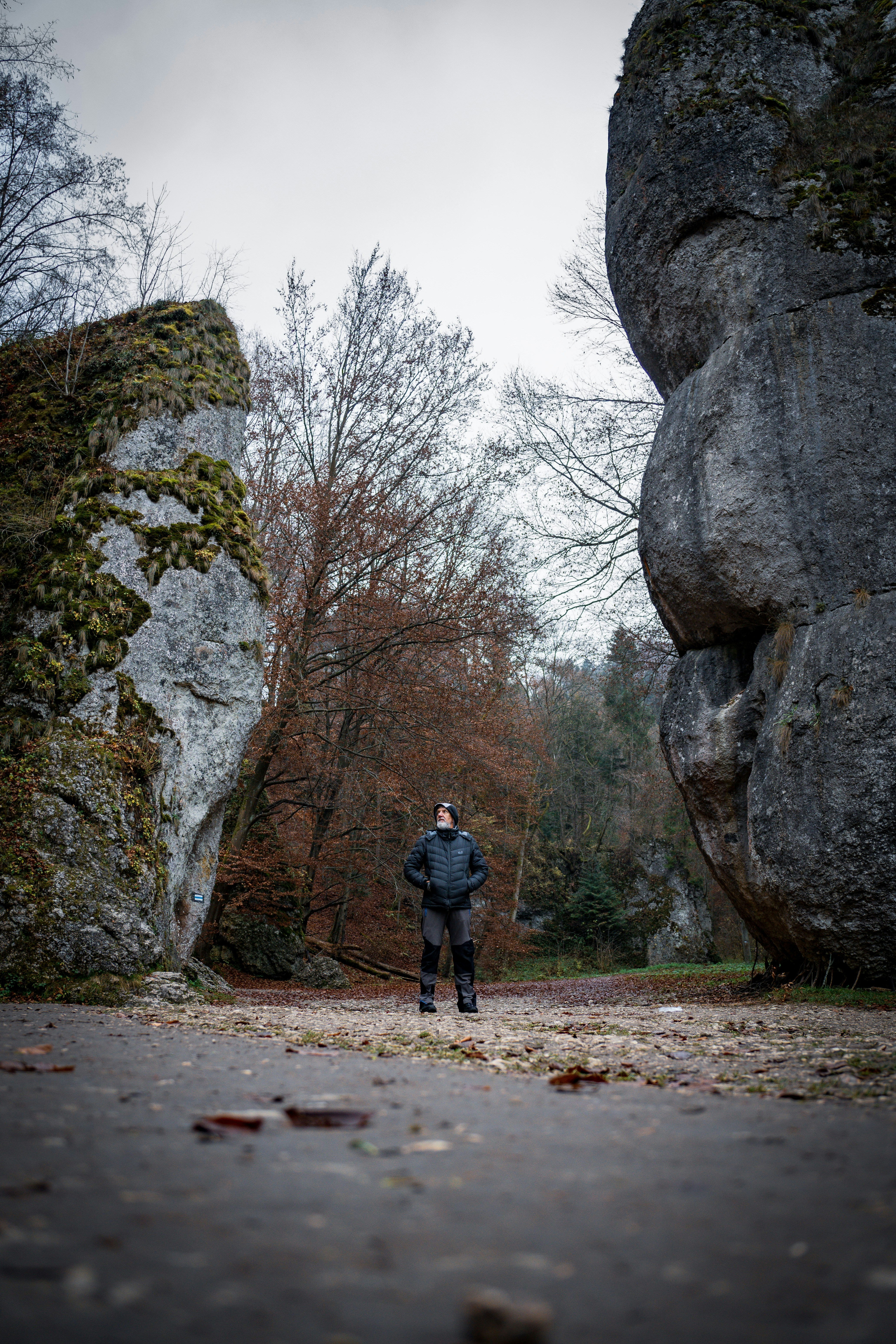 A man standing in front of a large rock formation