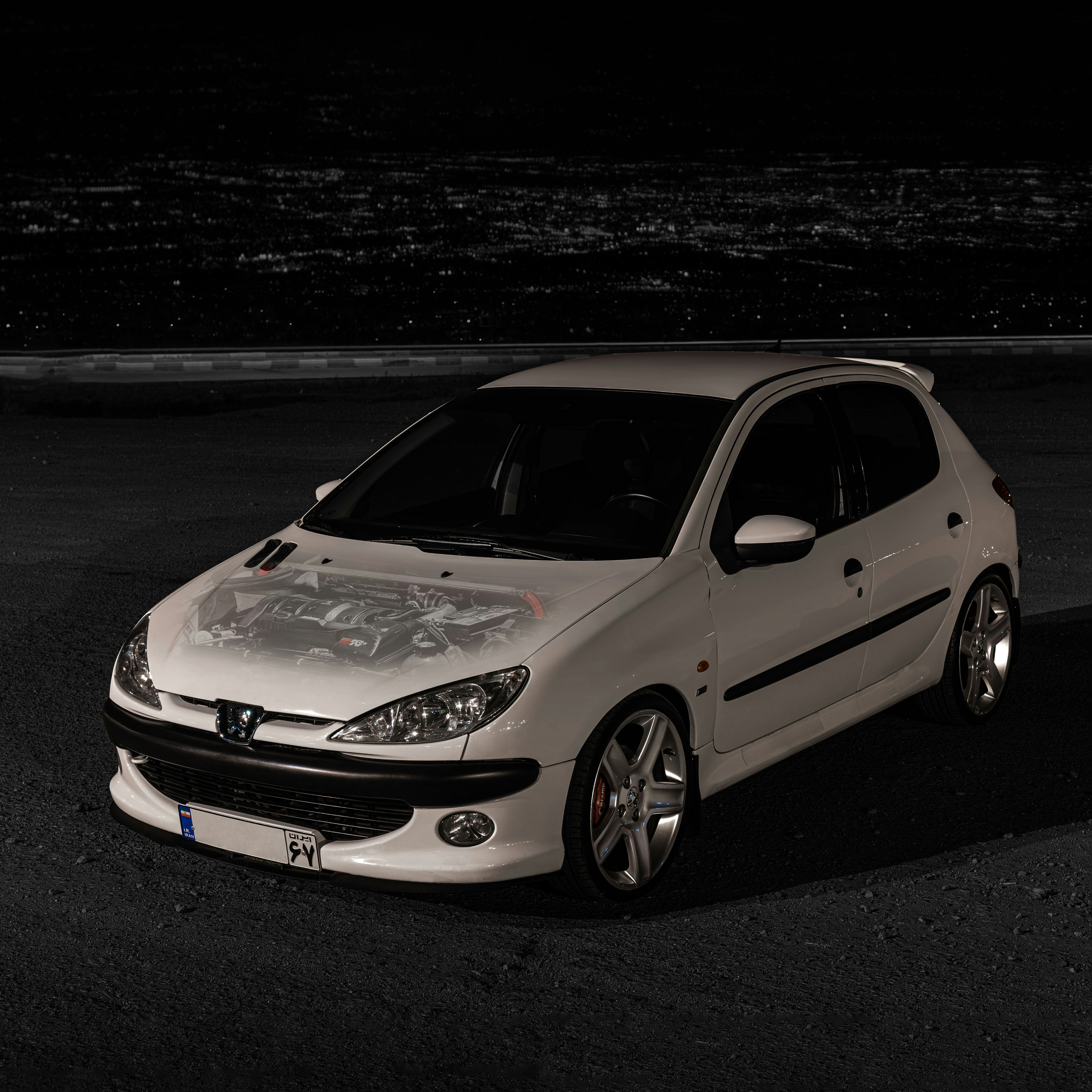 A white car parked in a parking lot at night