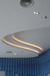 A large room with a curved ceiling and blue drapes