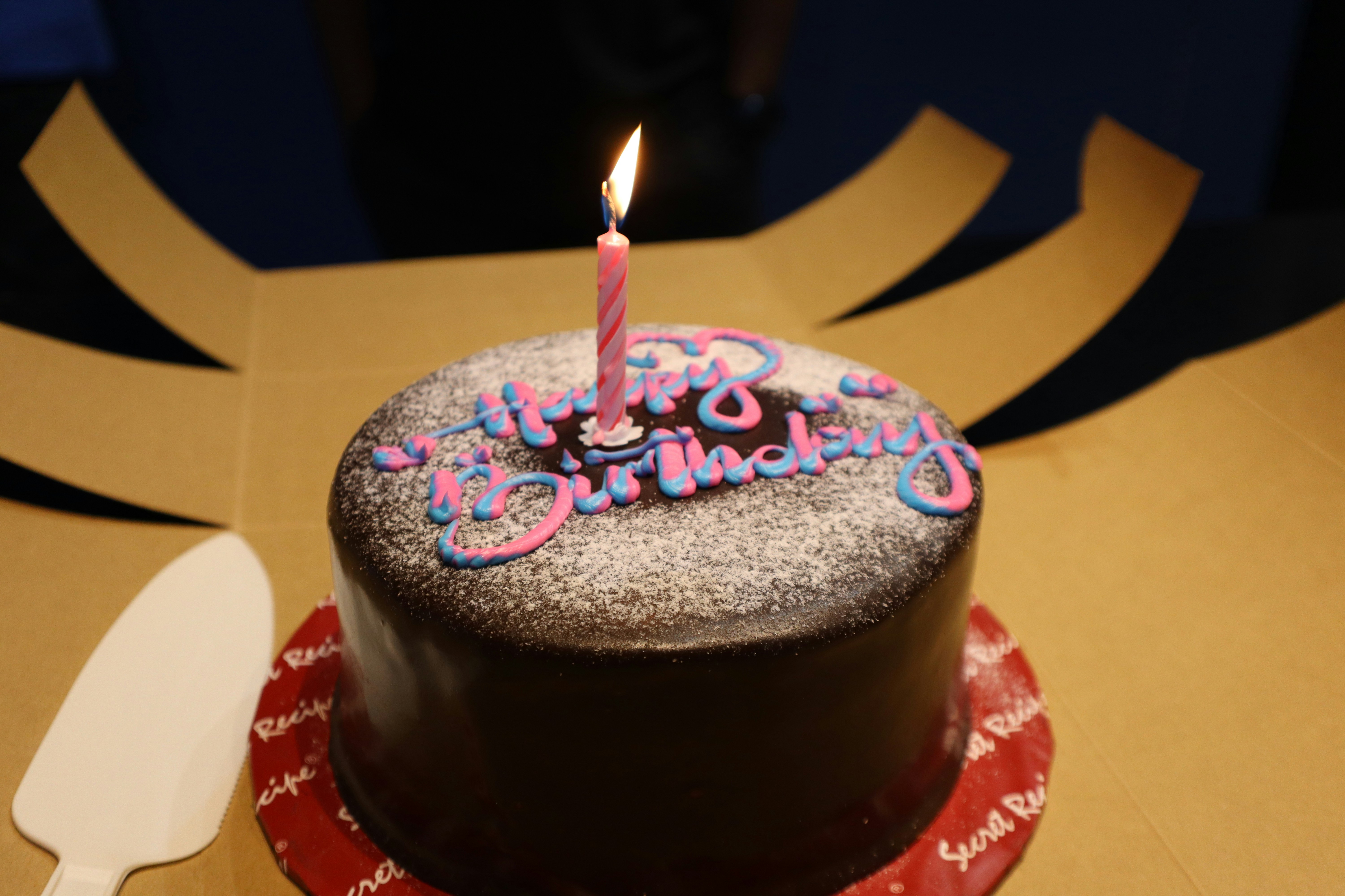 A birthday cake with a lit candle on top of it