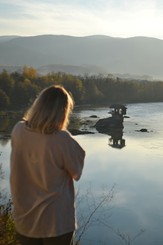 A woman standing next to a body of water