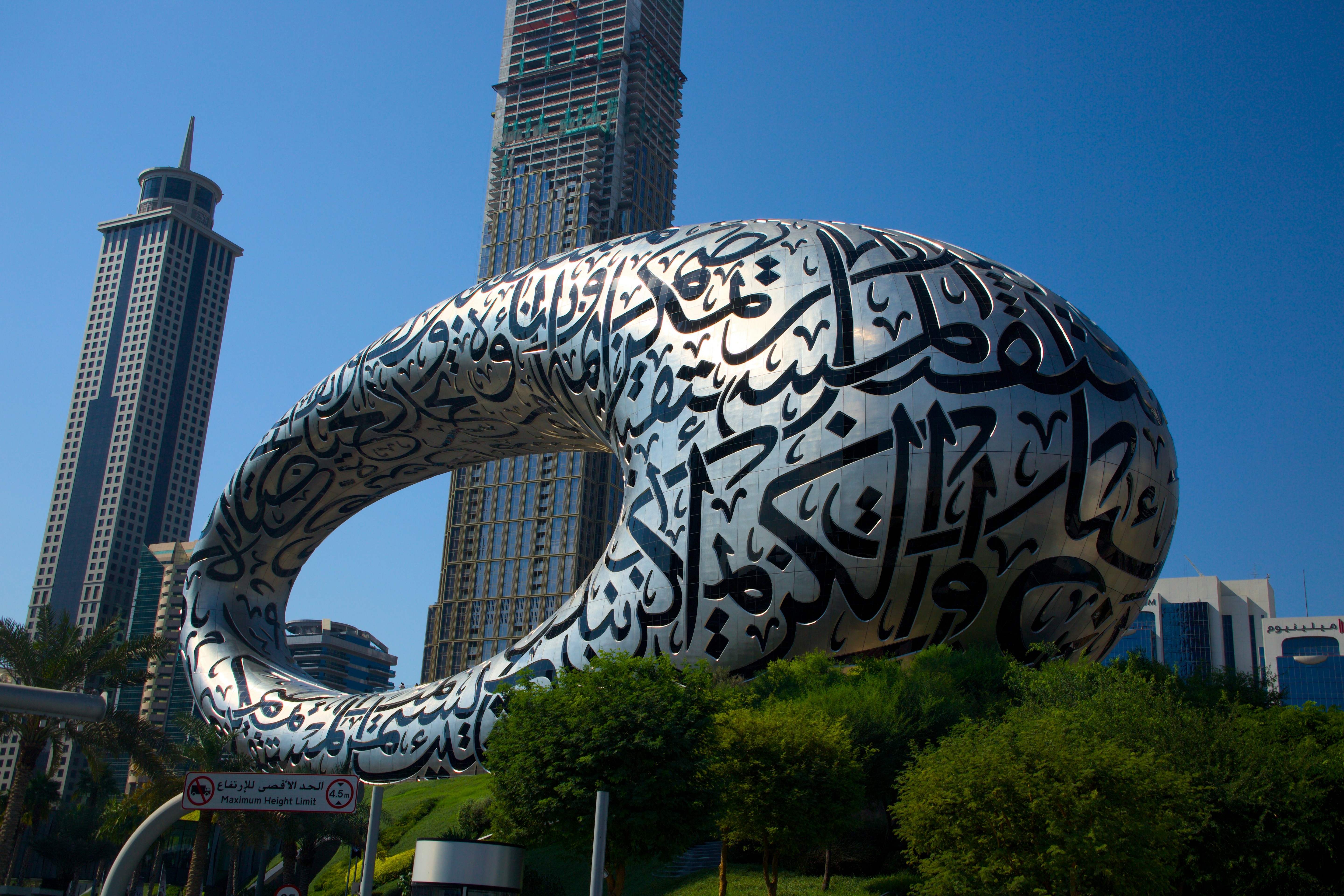 A large metal sculpture in front of a tall building