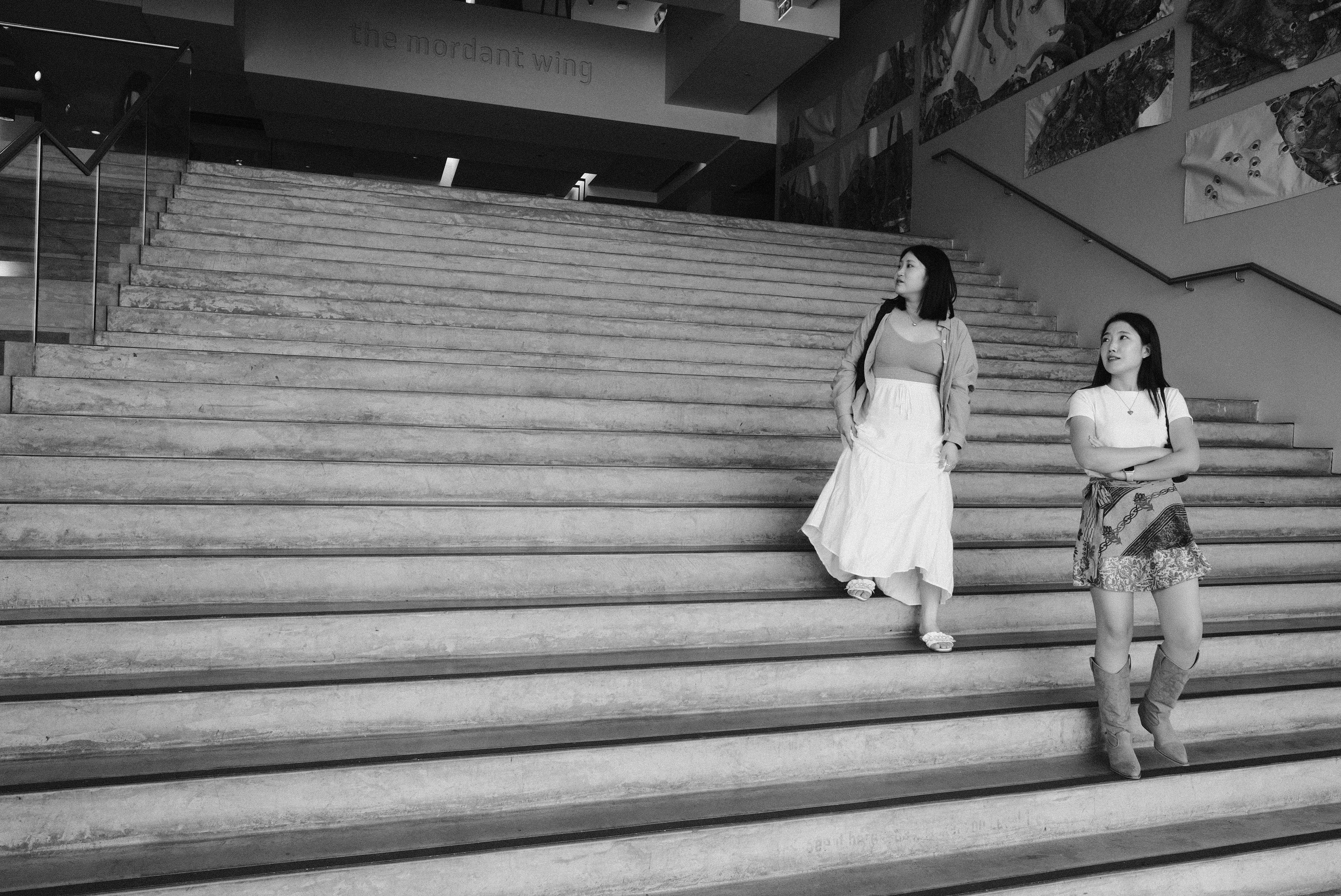 A couple of women walking down a set of stairs