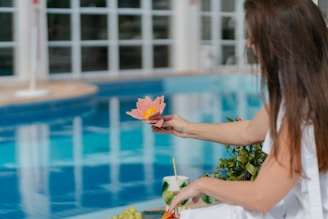 A woman in a white dress sitting by a pool