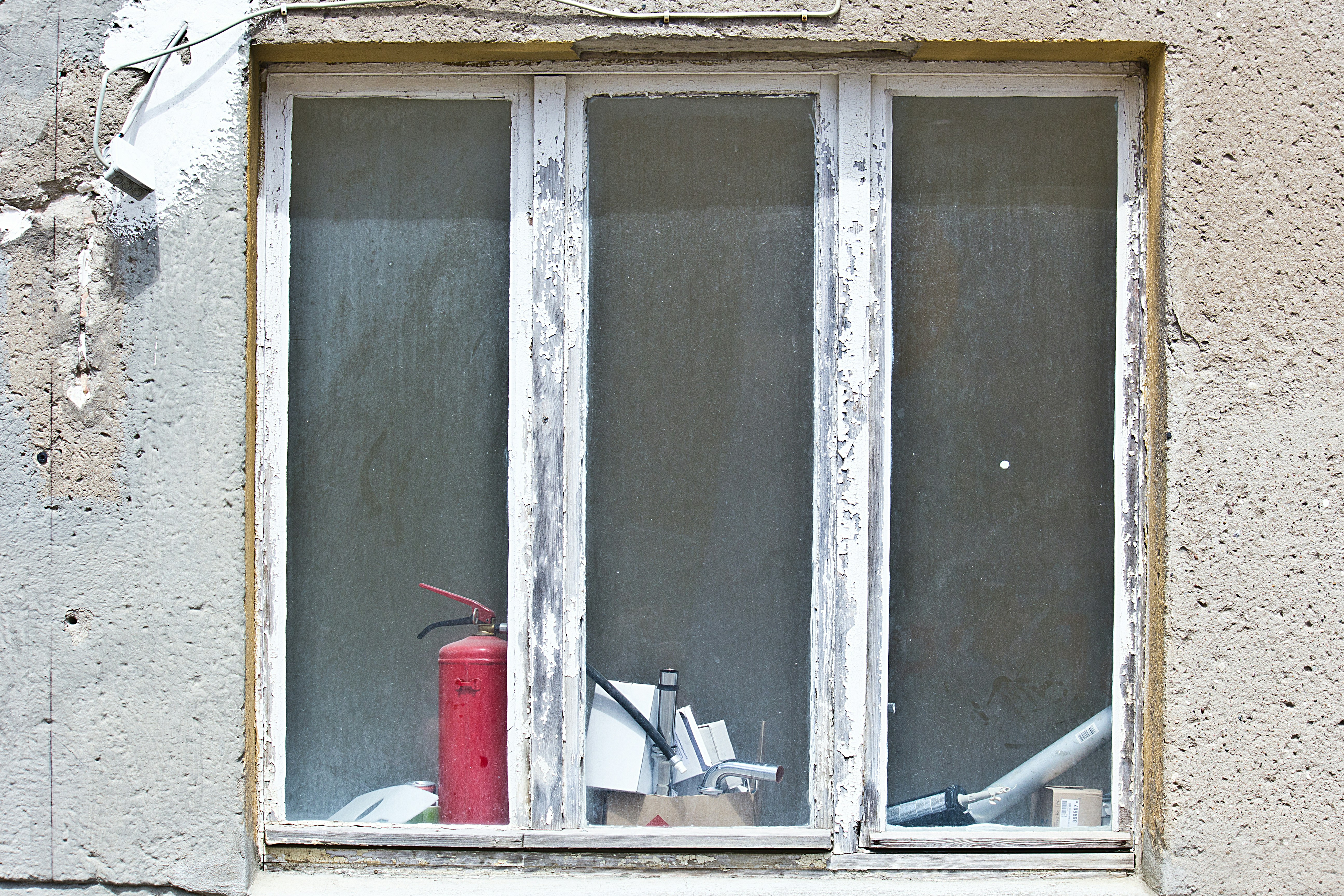 A red fire hydrant sitting in front of a window
