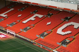 An empty stadium with a soccer field in the middle of it