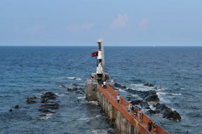 A long pier with a light house on top of it