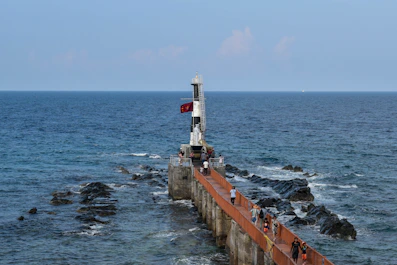 A long pier with a light house on top of it