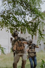 A group of men with guns walking through a field