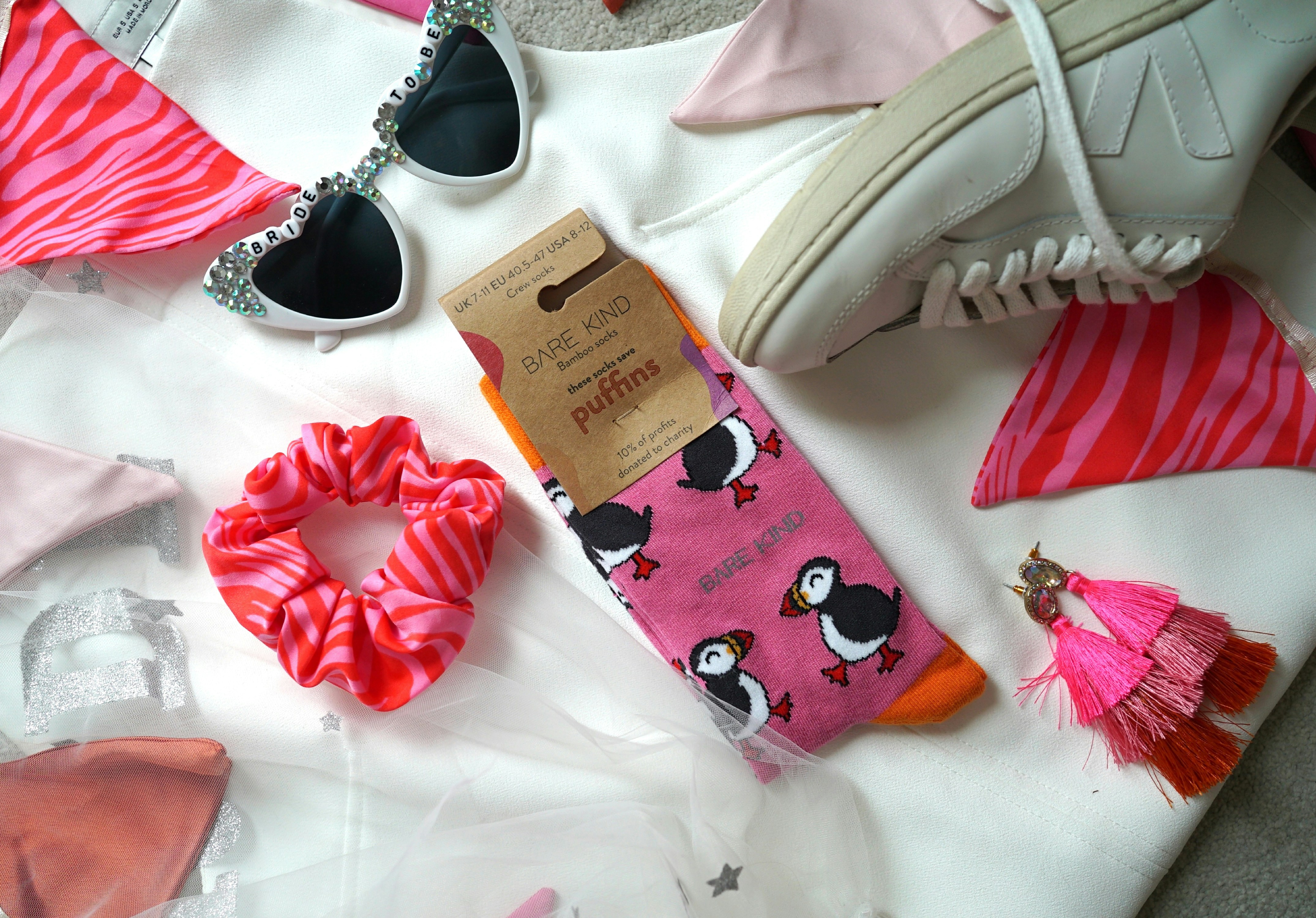 A pile of clothing and shoes on a bed