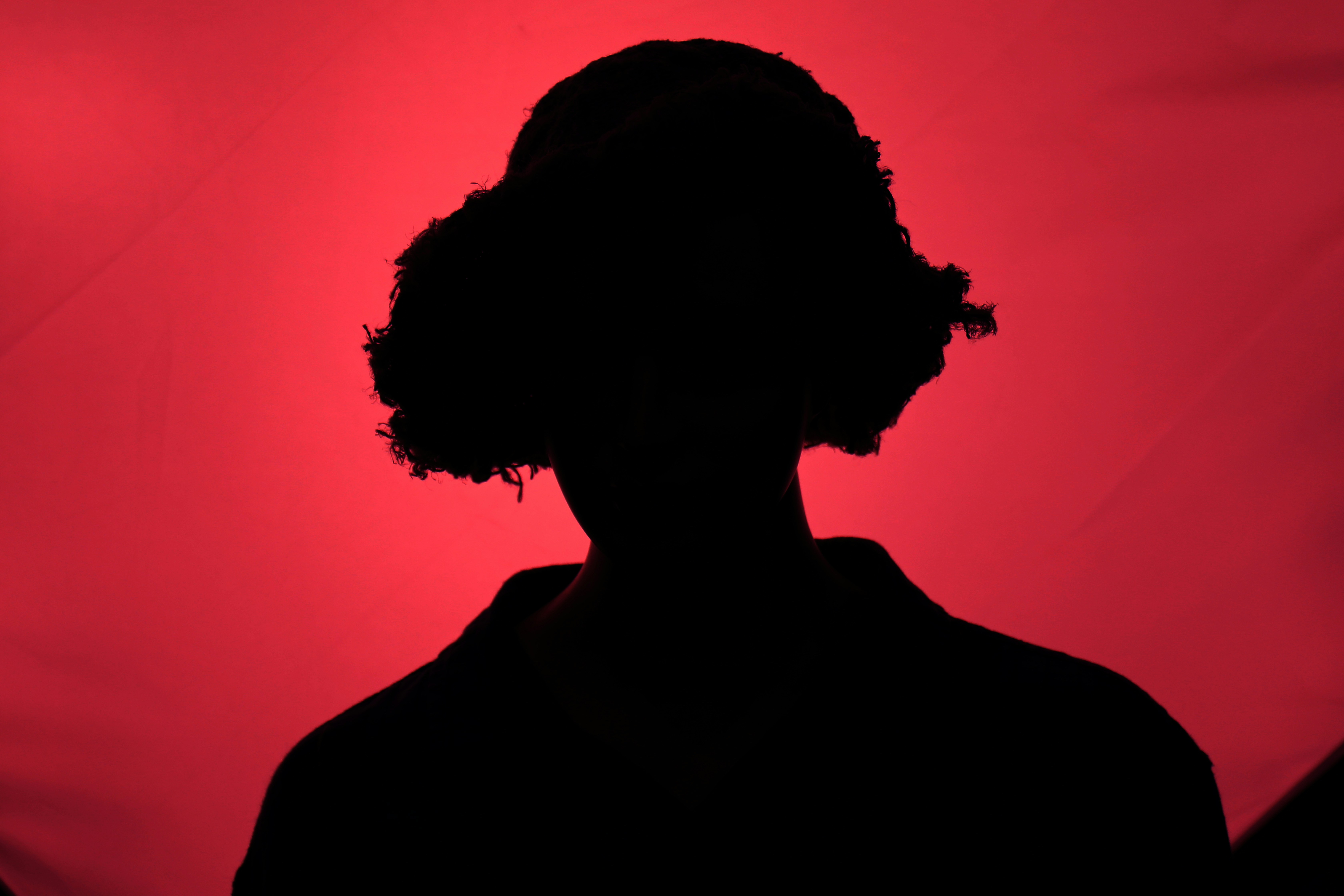 A silhouette of a woman against a red background - Free Photo on Unsplash