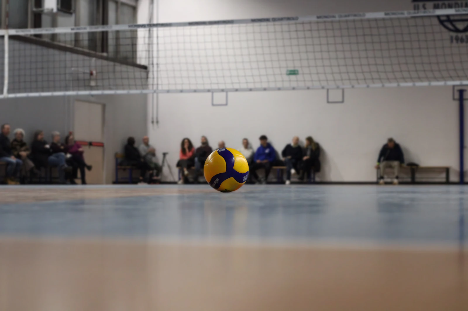 A volleyball resting on an empty indoor court